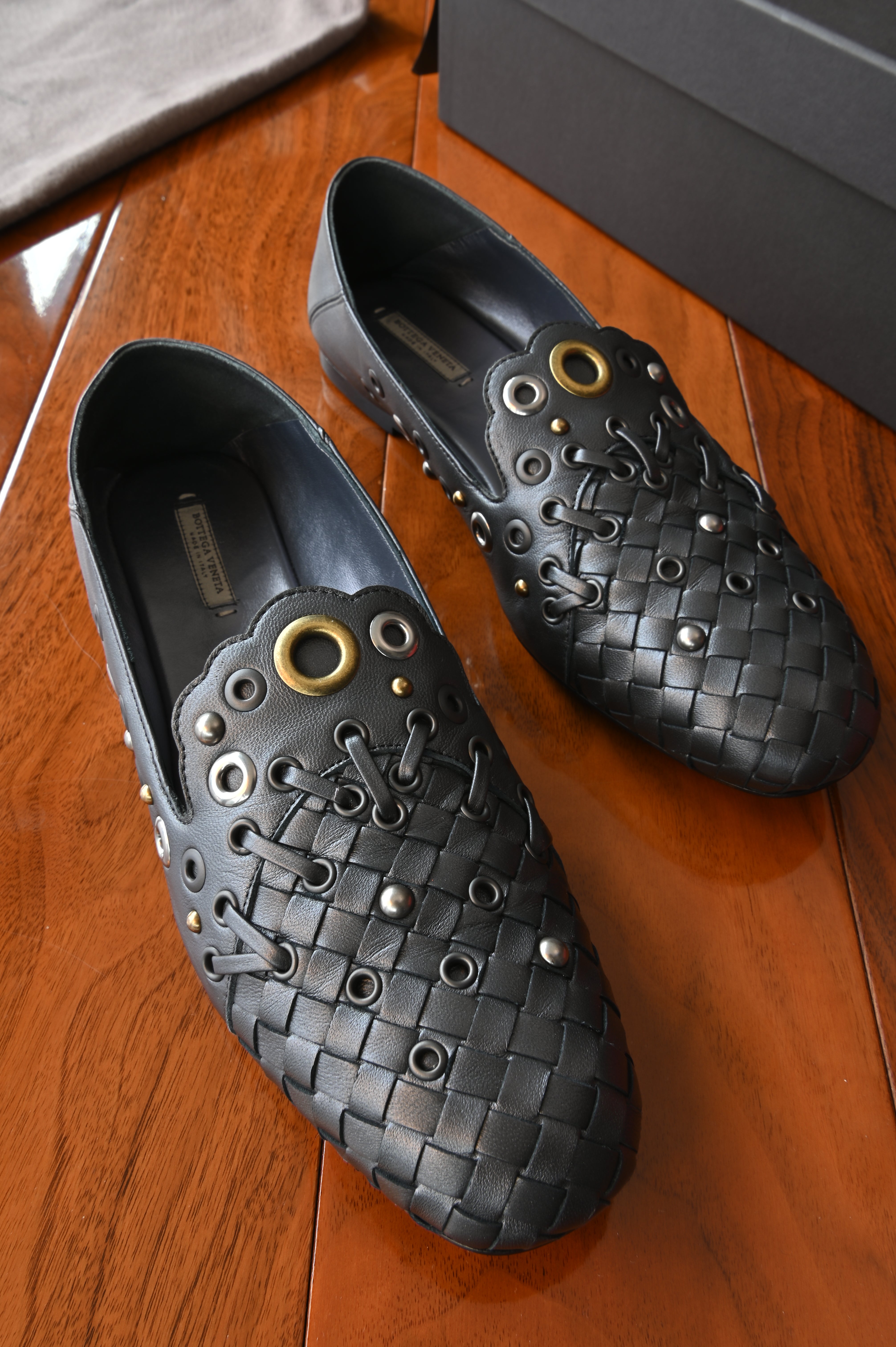 Authentic Bottega Veneta Black Intrecciato Eyelet Leather Loafers featuring signature woven leather toe, decorative eyelets and leather lace detailing, front pair view.