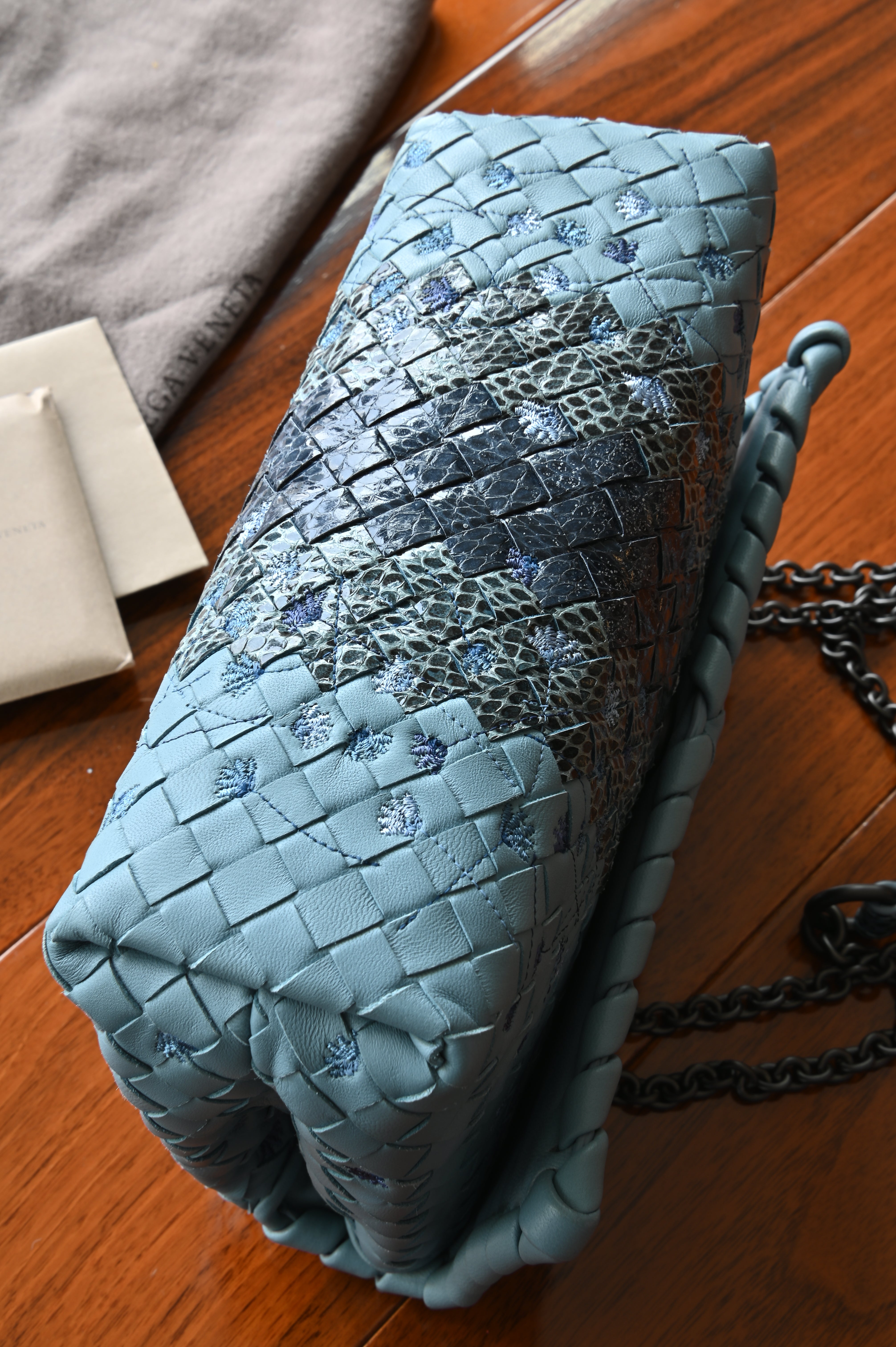 Authentic Bottega Veneta Blue Intrecciato Woven Crossbody Bag displaying the base and side profile with signature woven leather craftsmanship.
