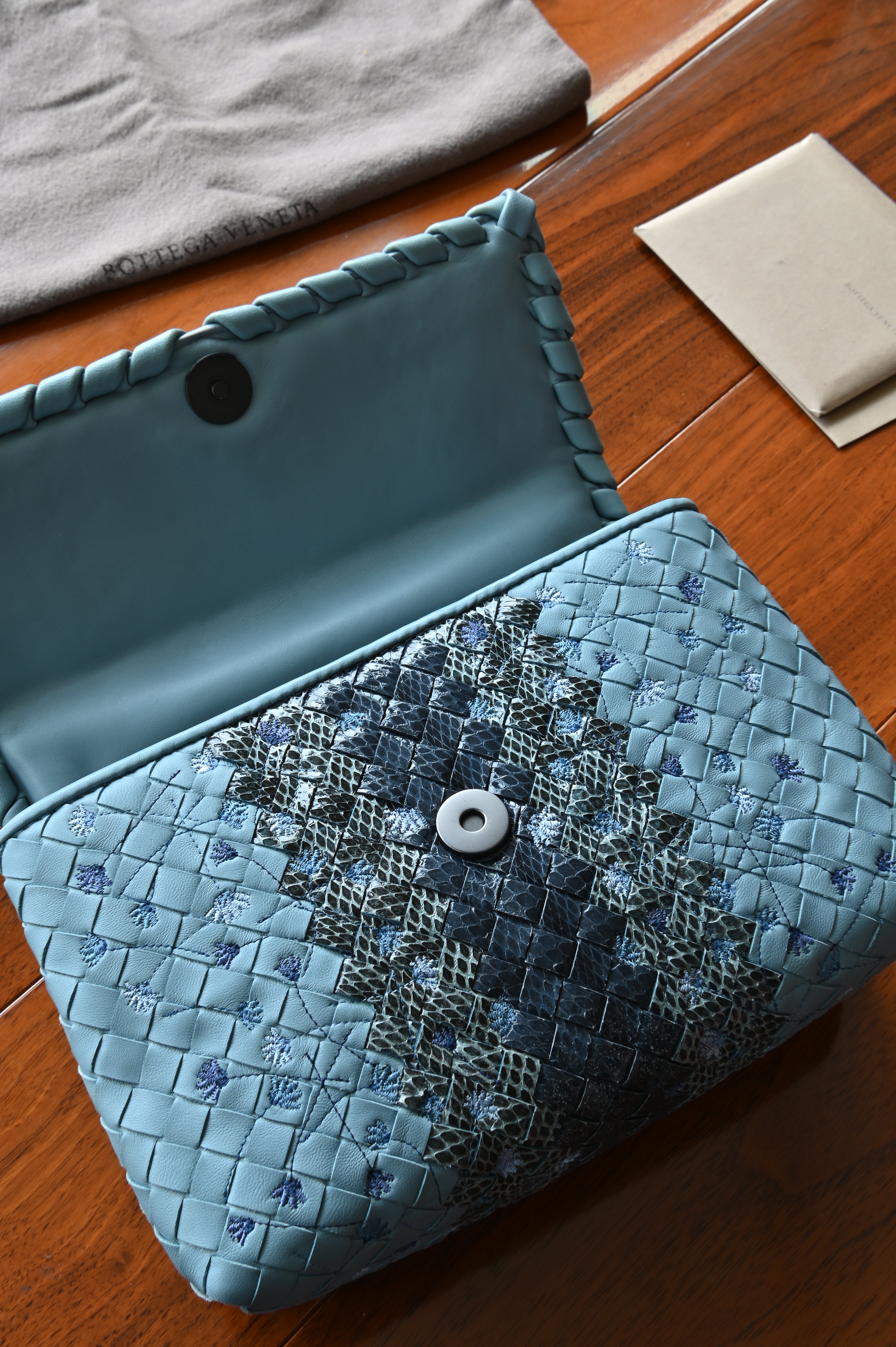 Authentic Bottega Veneta Blue Intrecciato Woven Crossbody Bag showing the leather-lined interior with magnetic flap closure.