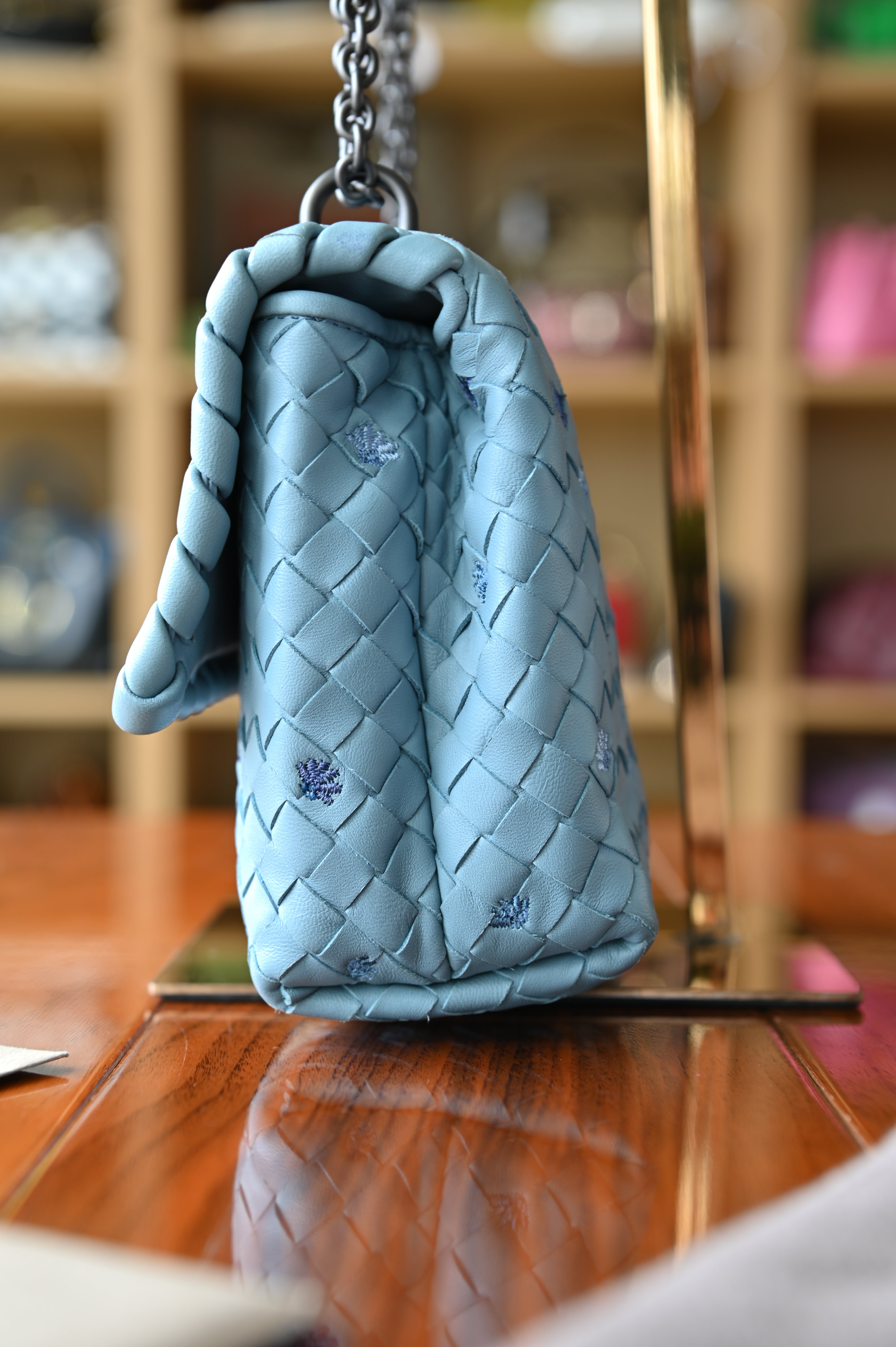 Authentic Bottega Veneta Blue Intrecciato Woven Crossbody Bag showing the right side profile highlighting the genuine python leather weave and structured silhouette.