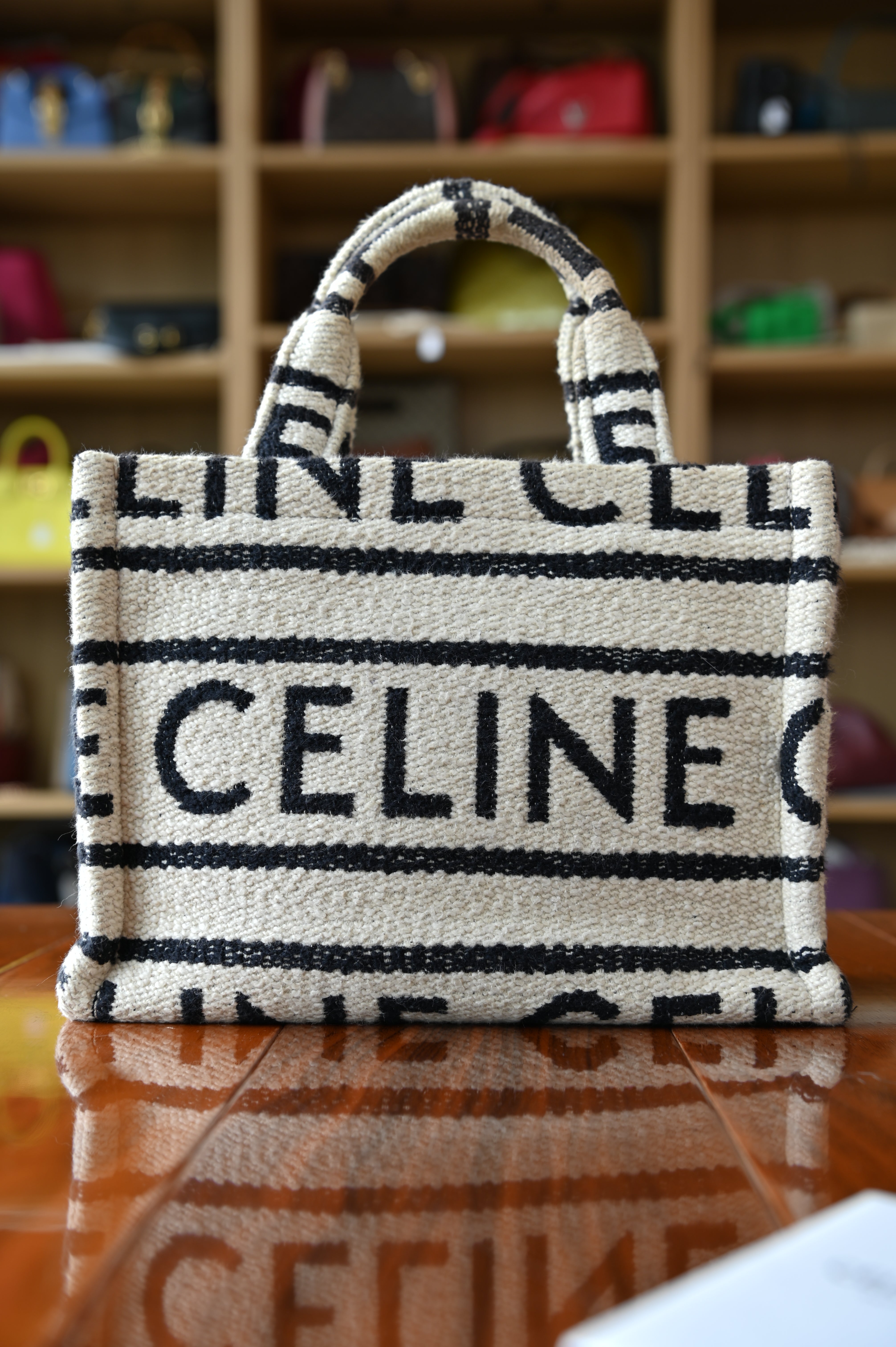 Authentic Celine Small White Canvas Tote Bag displayed from an angled front view highlighting the canvas body and leather trim.