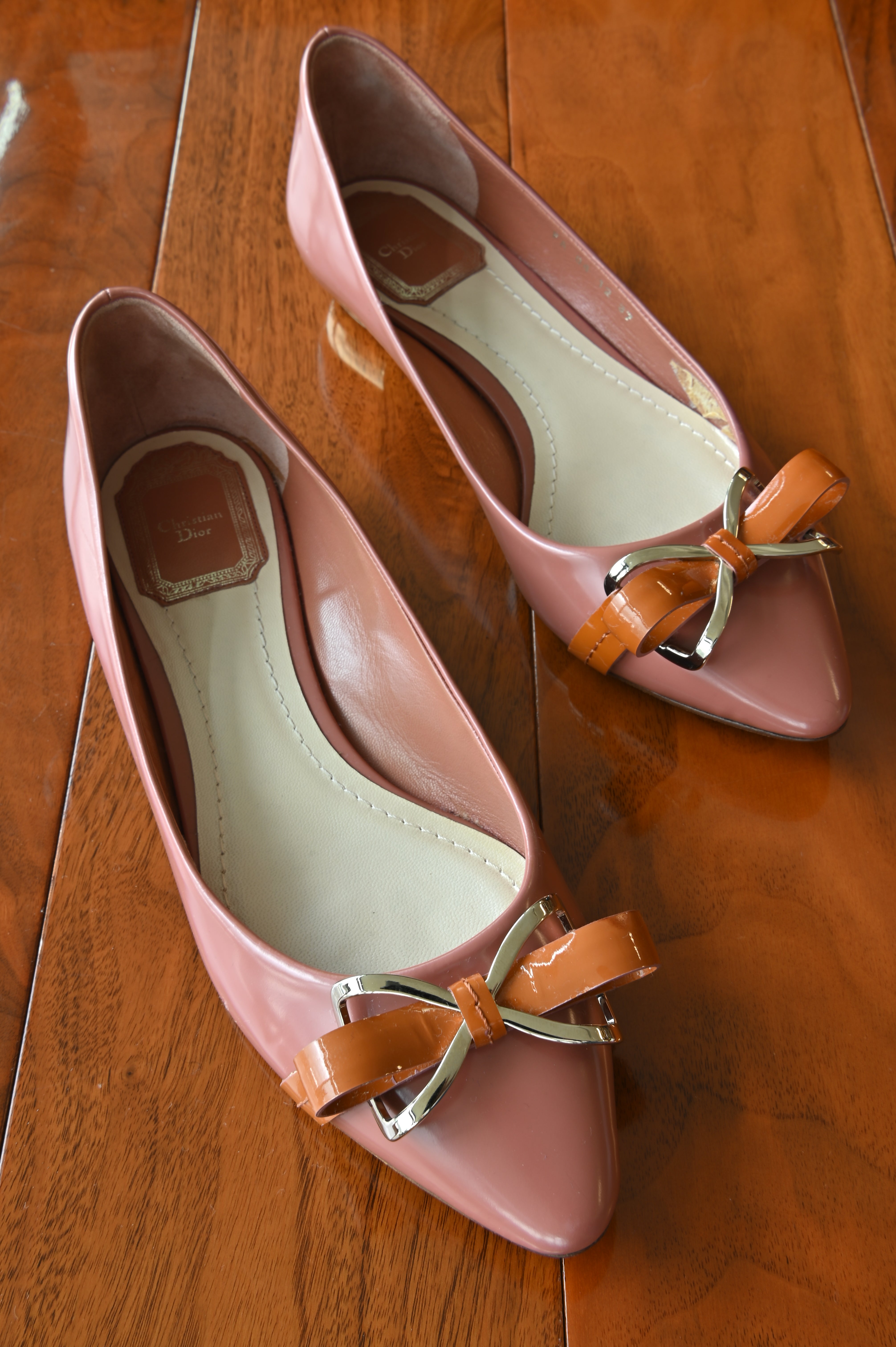 Authentic Christian Dior Dusty Rose Patent Ballet Flats featuring glossy patent leather, signature bow detail and elegant pointed silhouette, pair front view.