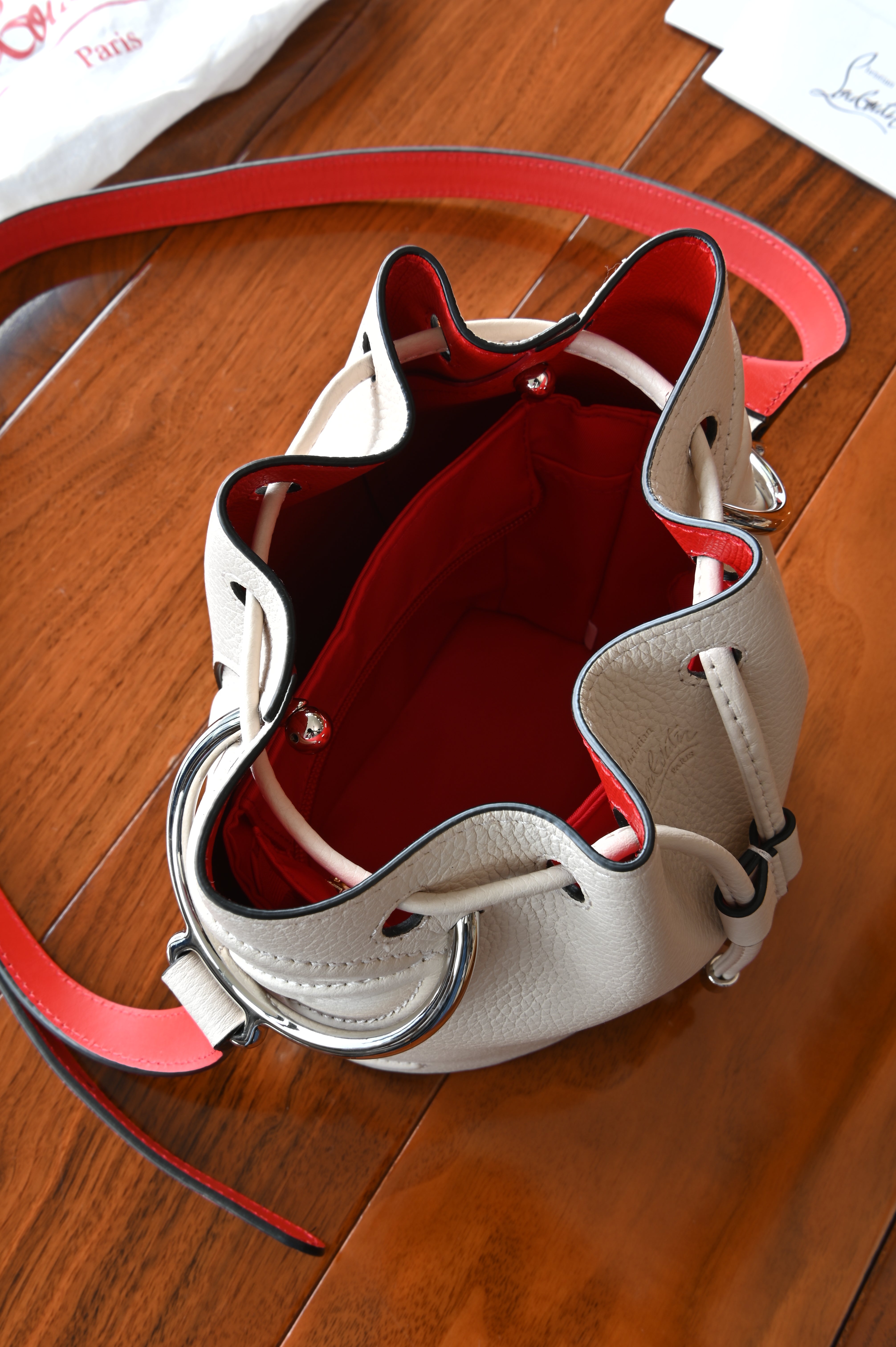 Authentic Christian Louboutin By My Side Bucket Bag showing the signature red interior and drawstring opening.
