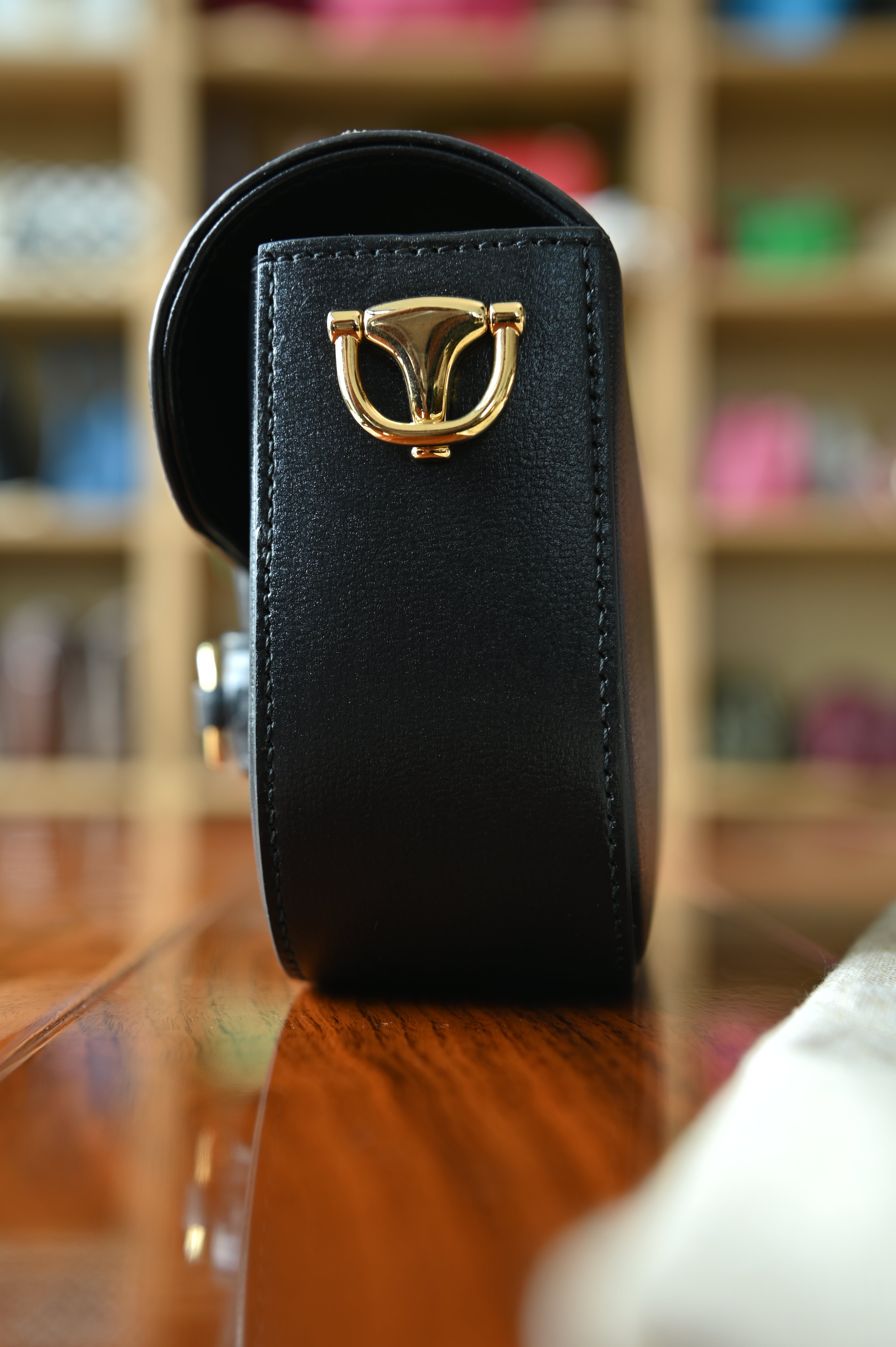Left side profile of the authentic Gucci Horsebit 1955 Mini Shoulder Bag showcasing its structured silhouette and polished gold-tone side hardware.