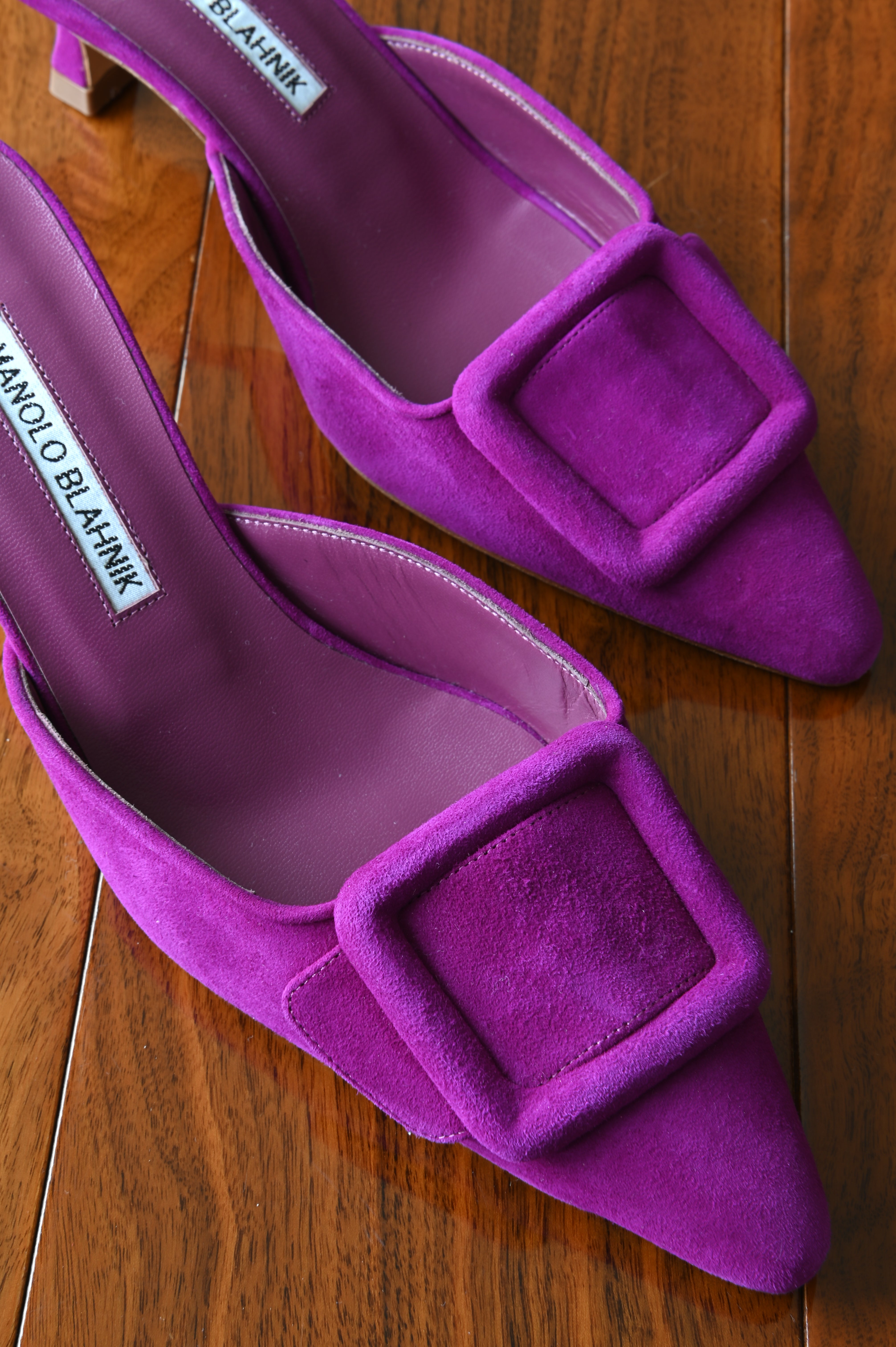 Close-up of the oversized tonal suede buckle and pointed toe on the authentic Manolo Blahnik purple suede buckle mules