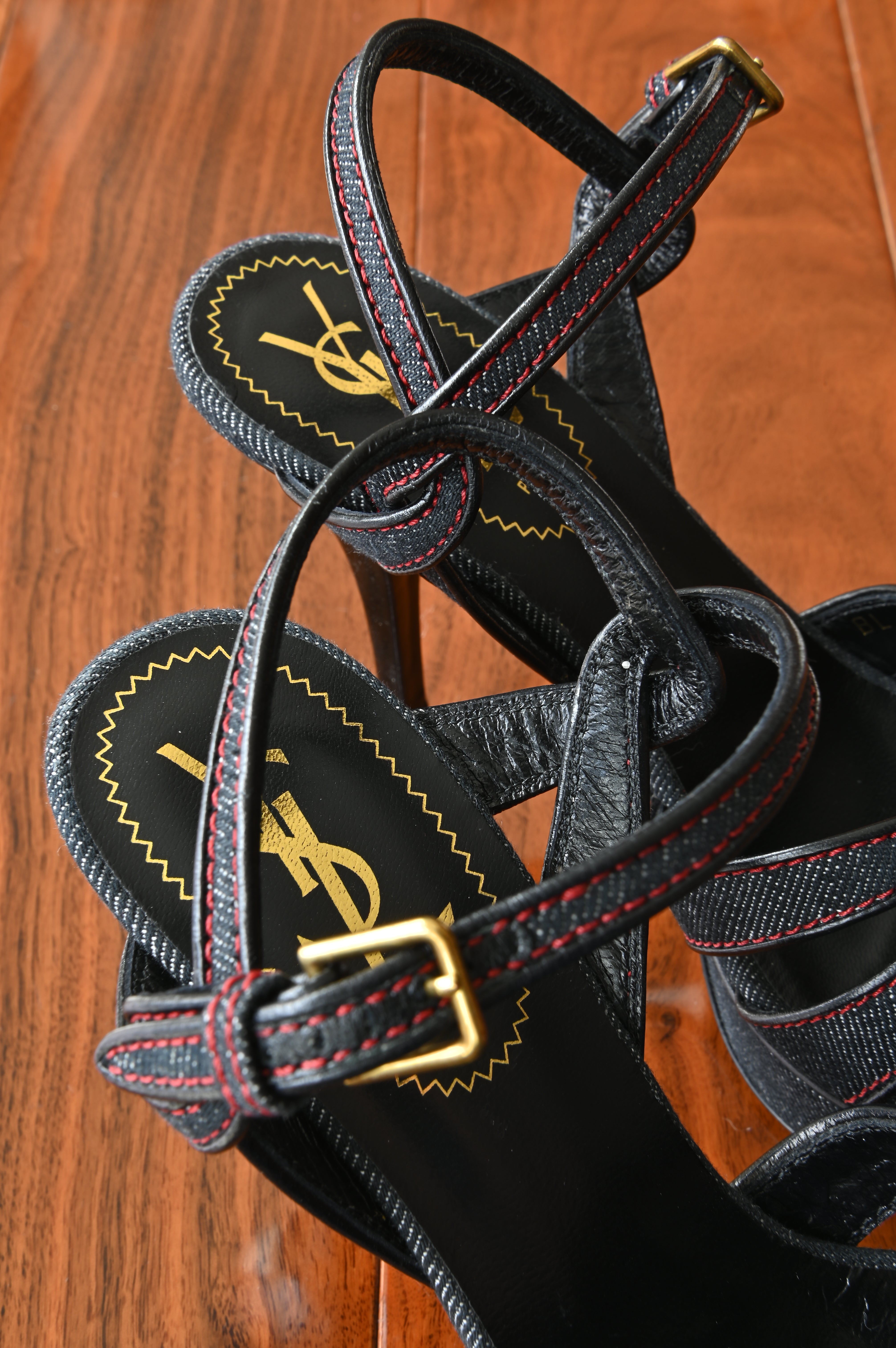 Close-up of the adjustable ankle strap with gold-tone buckle, black leather lining, and premium craftsmanship of the authentic Saint Laurent Tribute Platform Sandals.