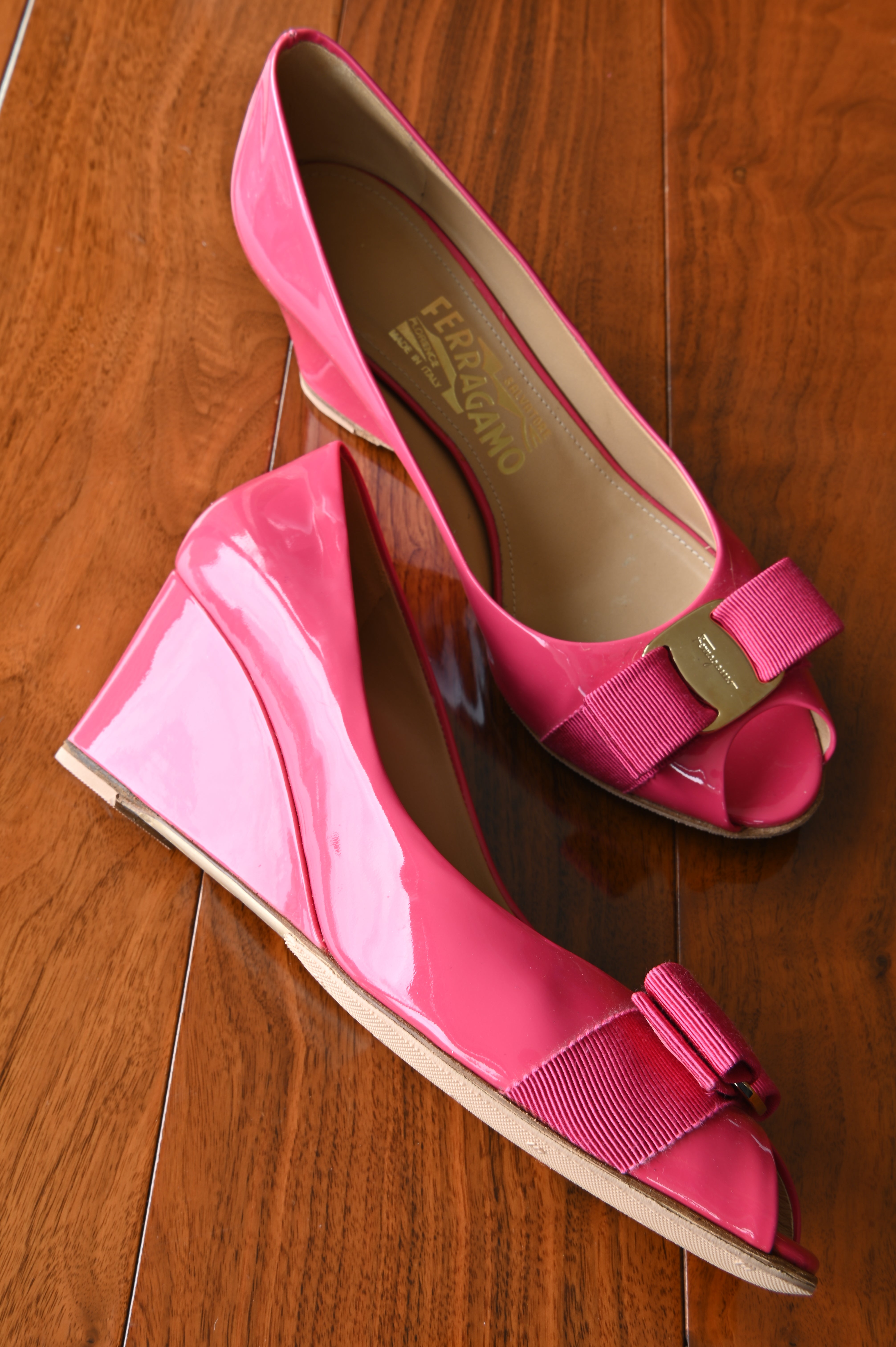 Side profile of authentic Salvatore Ferragamo pink patent leather Vara Bow Wedge Pumps highlighting the approximately 2.5-inch wedge heel and peep-toe design.