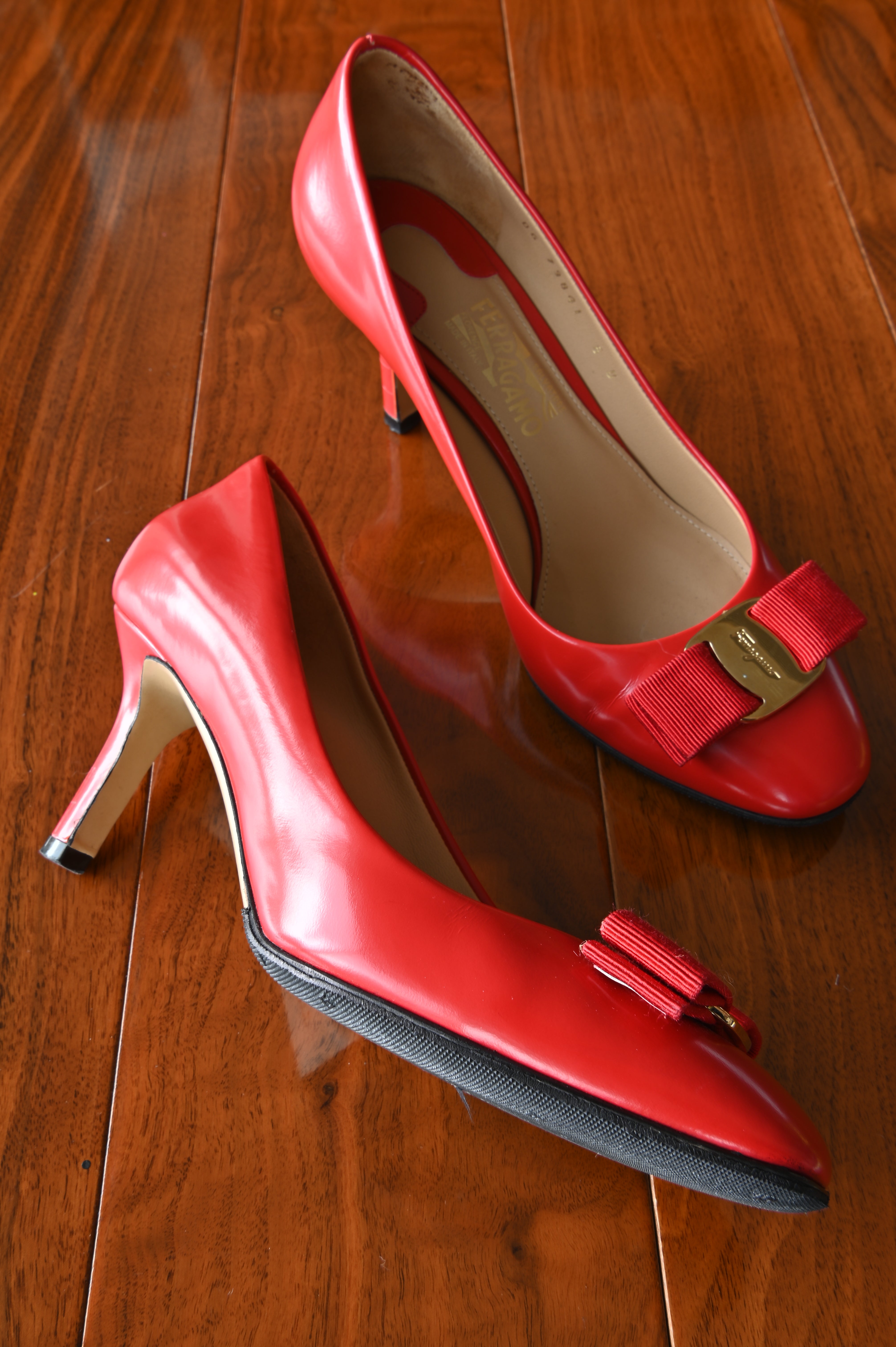 Side profile of authentic Salvatore Ferragamo Vara red leather pumps highlighting the elegant mid-height heel and smooth leather construction.