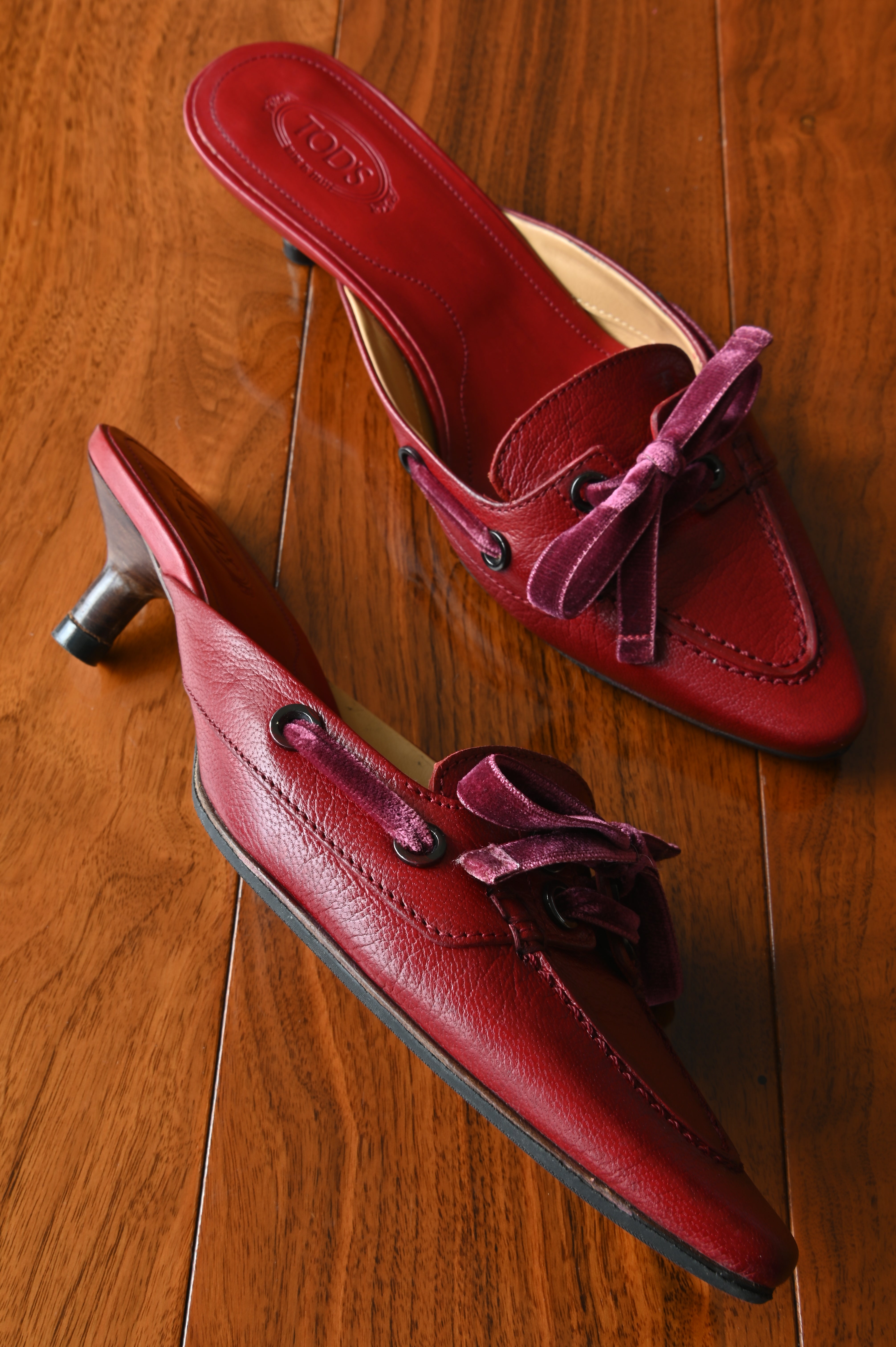 Side profile of authentic Tod’s burgundy leather kitten heel mules showcasing the elegant silhouette and comfortable kitten heel.