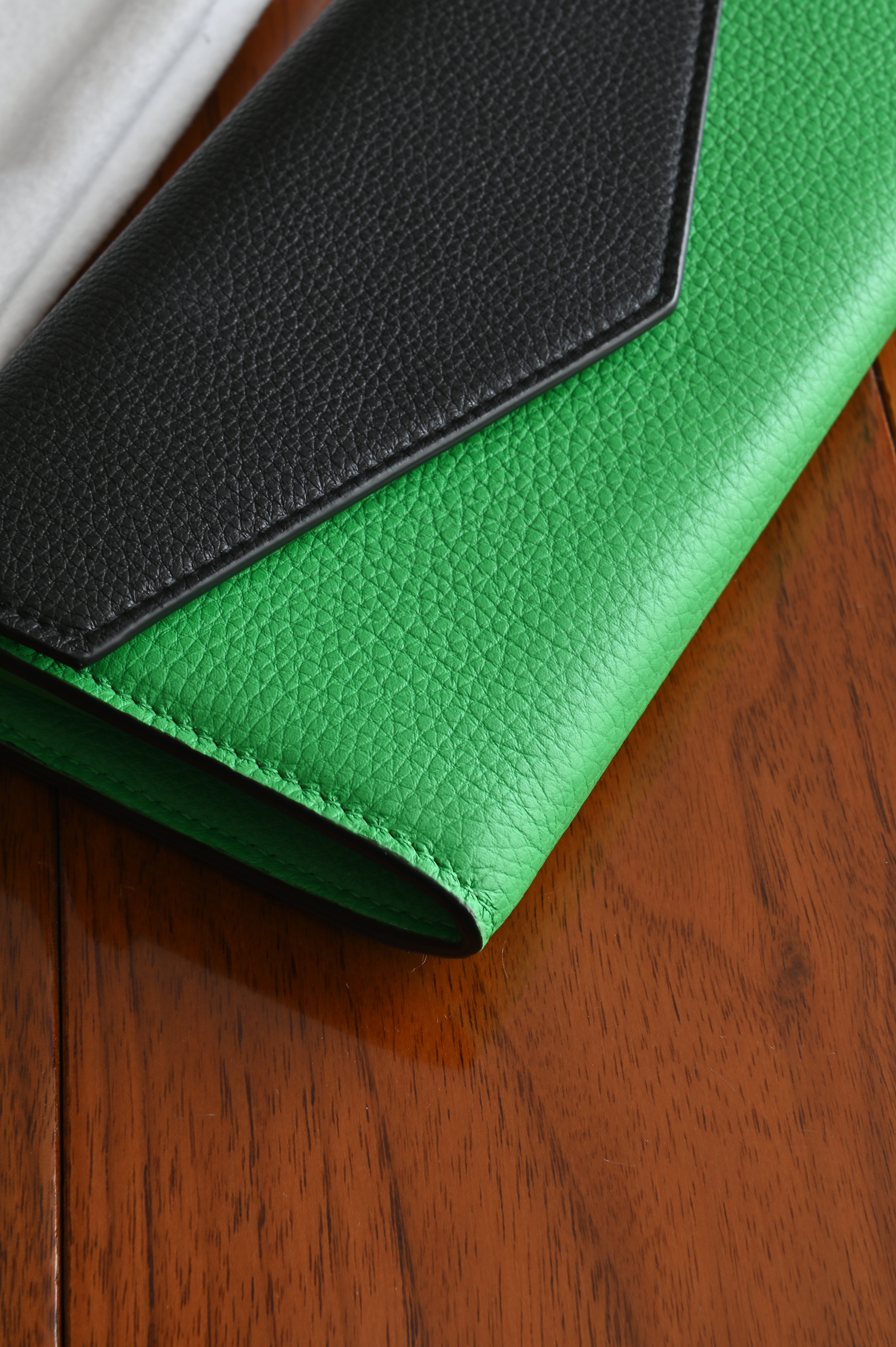 Bottega Veneta long envelope wallet in black and parakeet green left