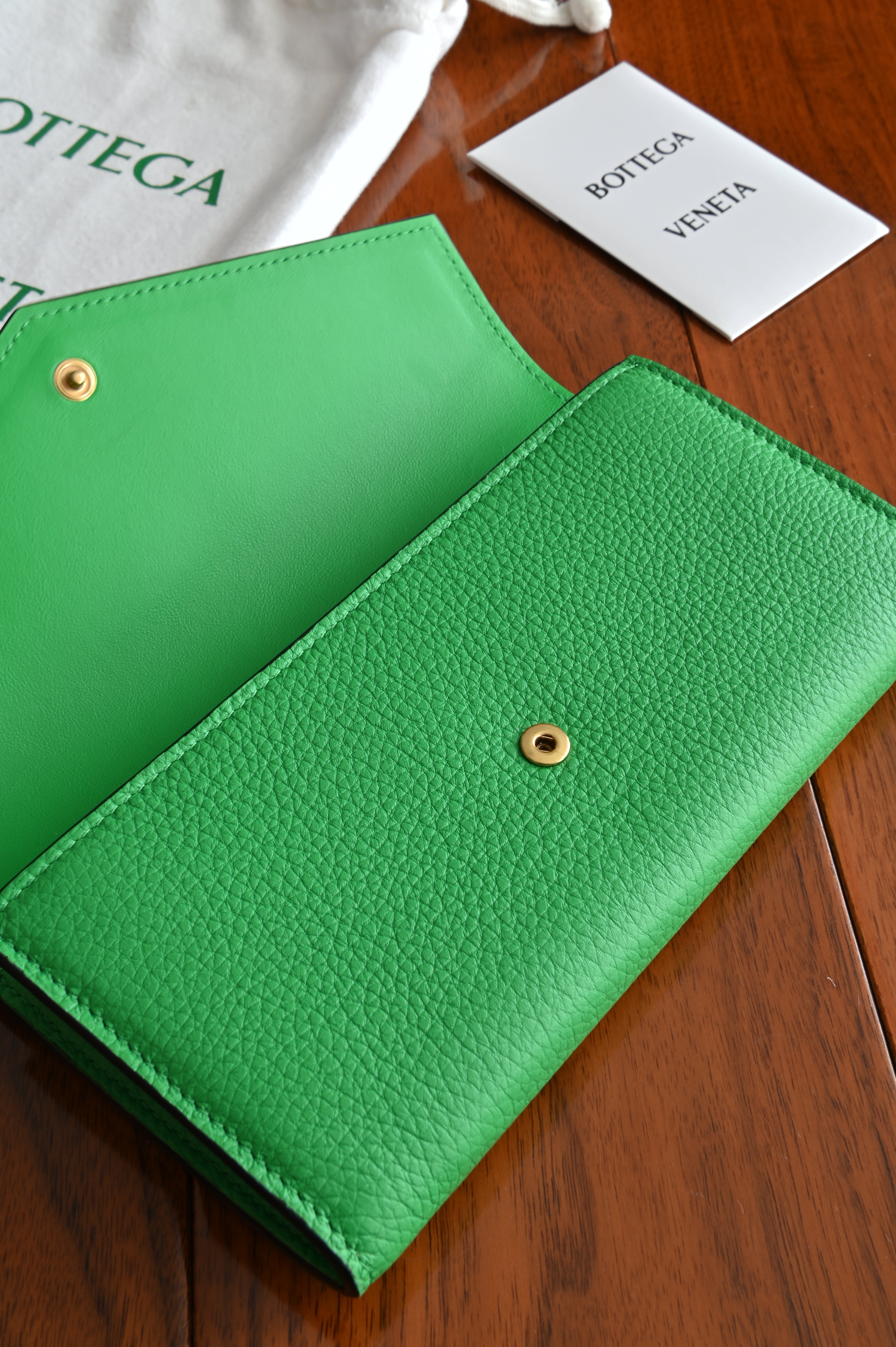 Bottega Veneta long envelope wallet in black and parakeet green open