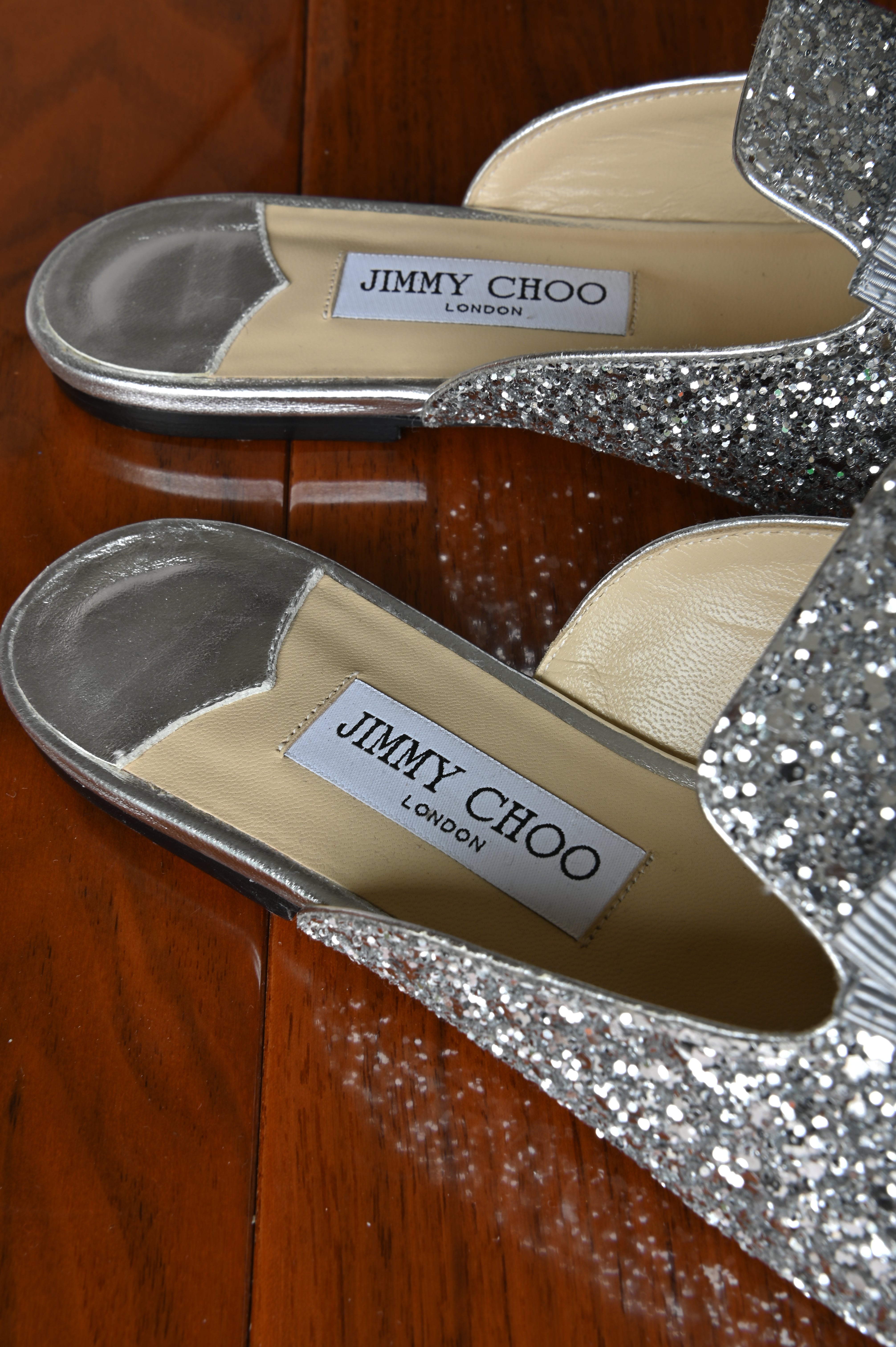 Jimmy Choo Silver Flat Mules logo