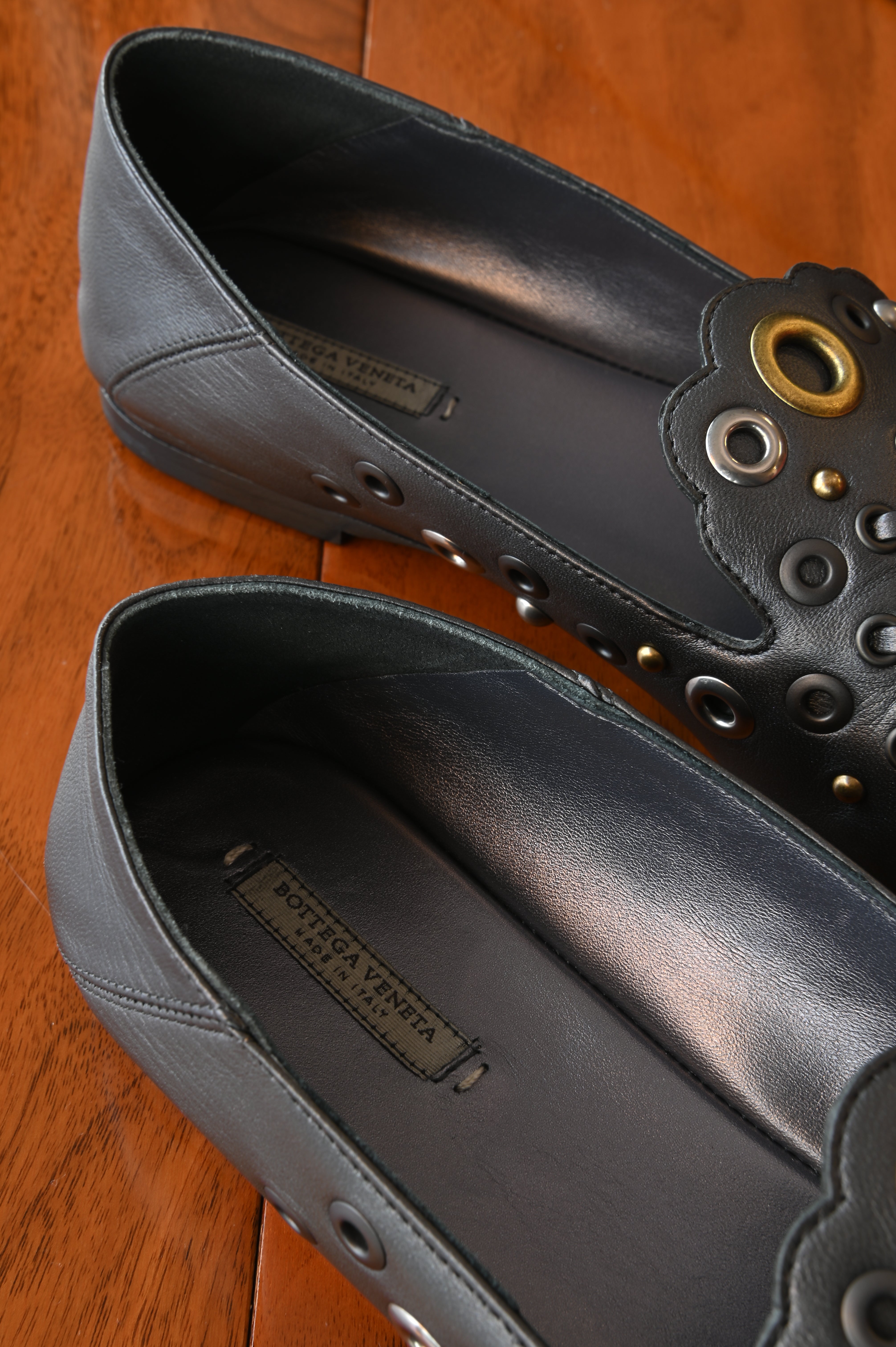 Authentic Bottega Veneta Black Intrecciato Eyelet Leather Loafers showing the leather-lined interior with Bottega Veneta branding and clean footbeds.