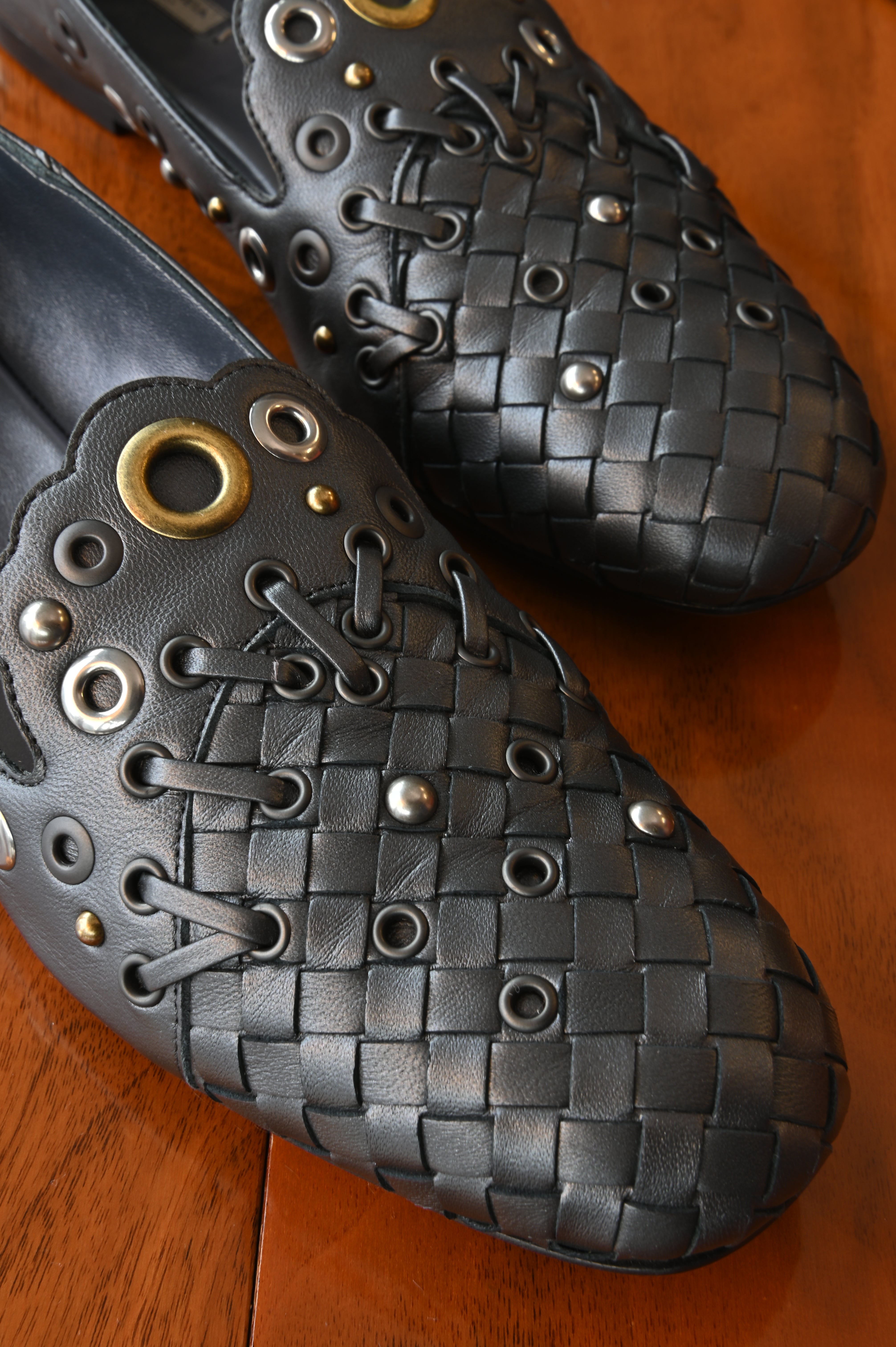 Close-up of the authentic Bottega Veneta Black Intrecciato Eyelet Leather Loafers showcasing the signature woven leather, decorative eyelets and leather lace detailing.