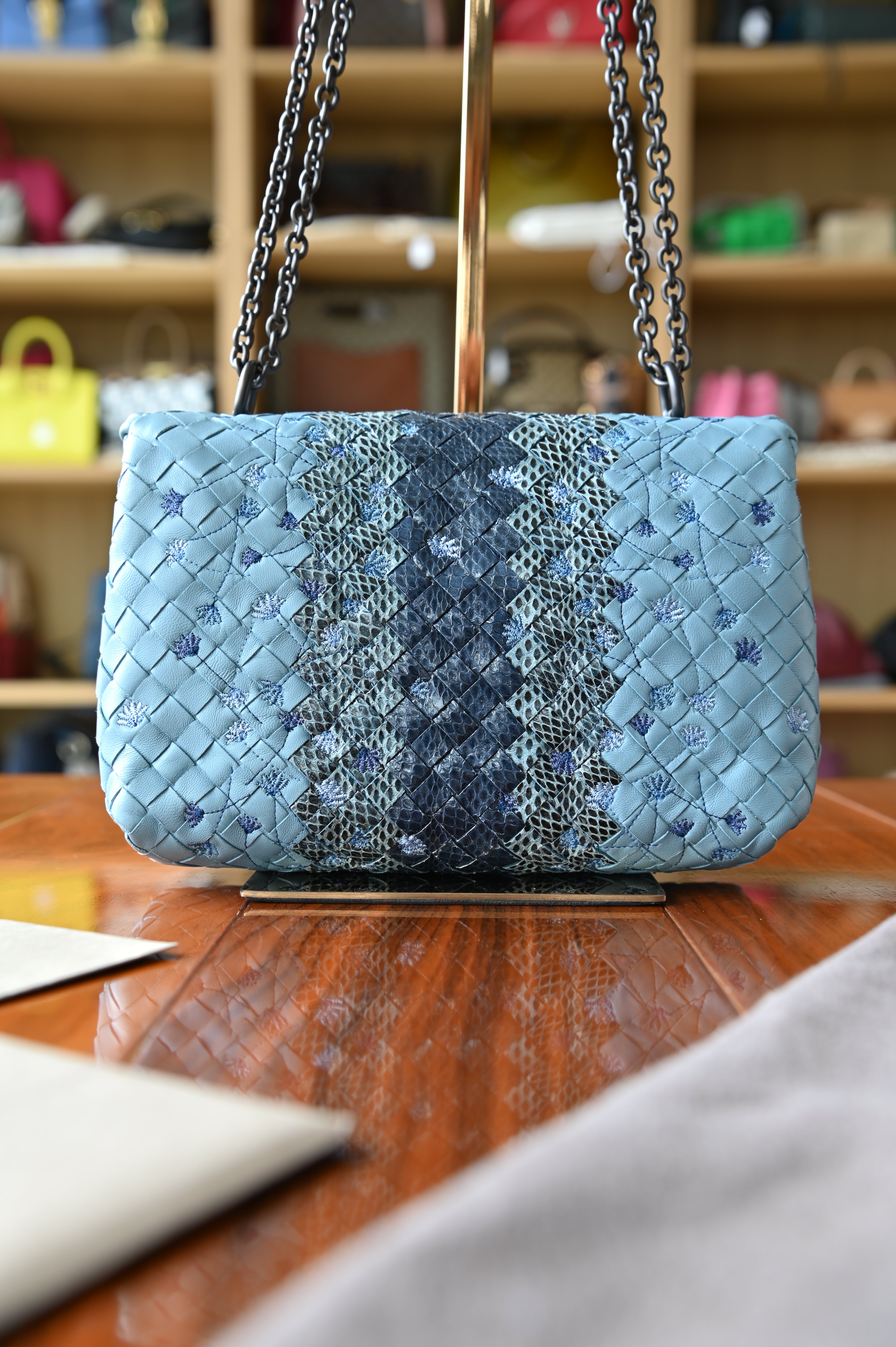 Authentic Bottega Veneta Blue Intrecciato Woven Crossbody Bag shown from a front angled view highlighting the woven python leather construction and chain strap.