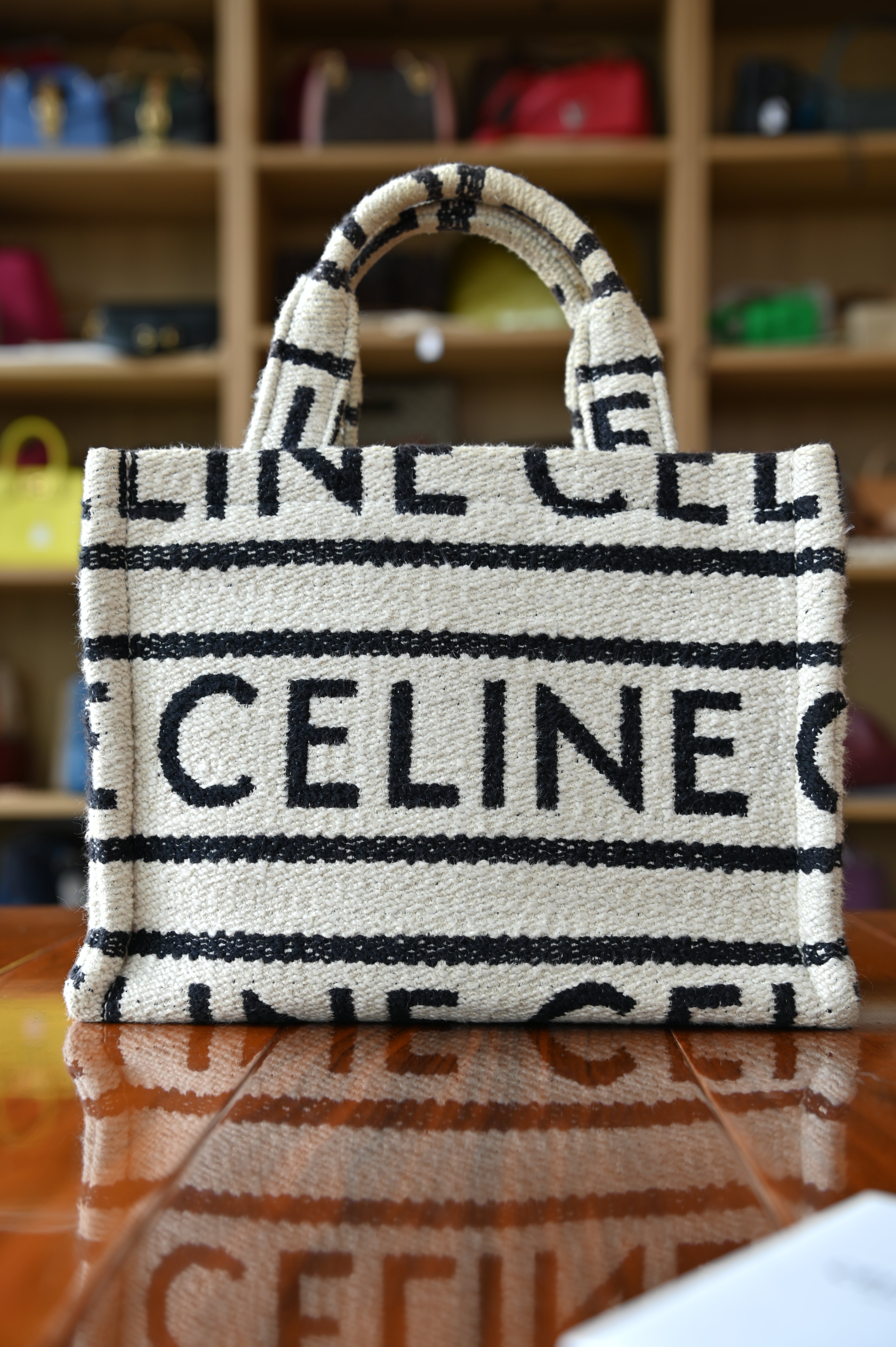 Authentic Celine Small White Canvas Tote Bag featuring signature CELINE logo canvas, brown leather trim and rolled top handles, front view.