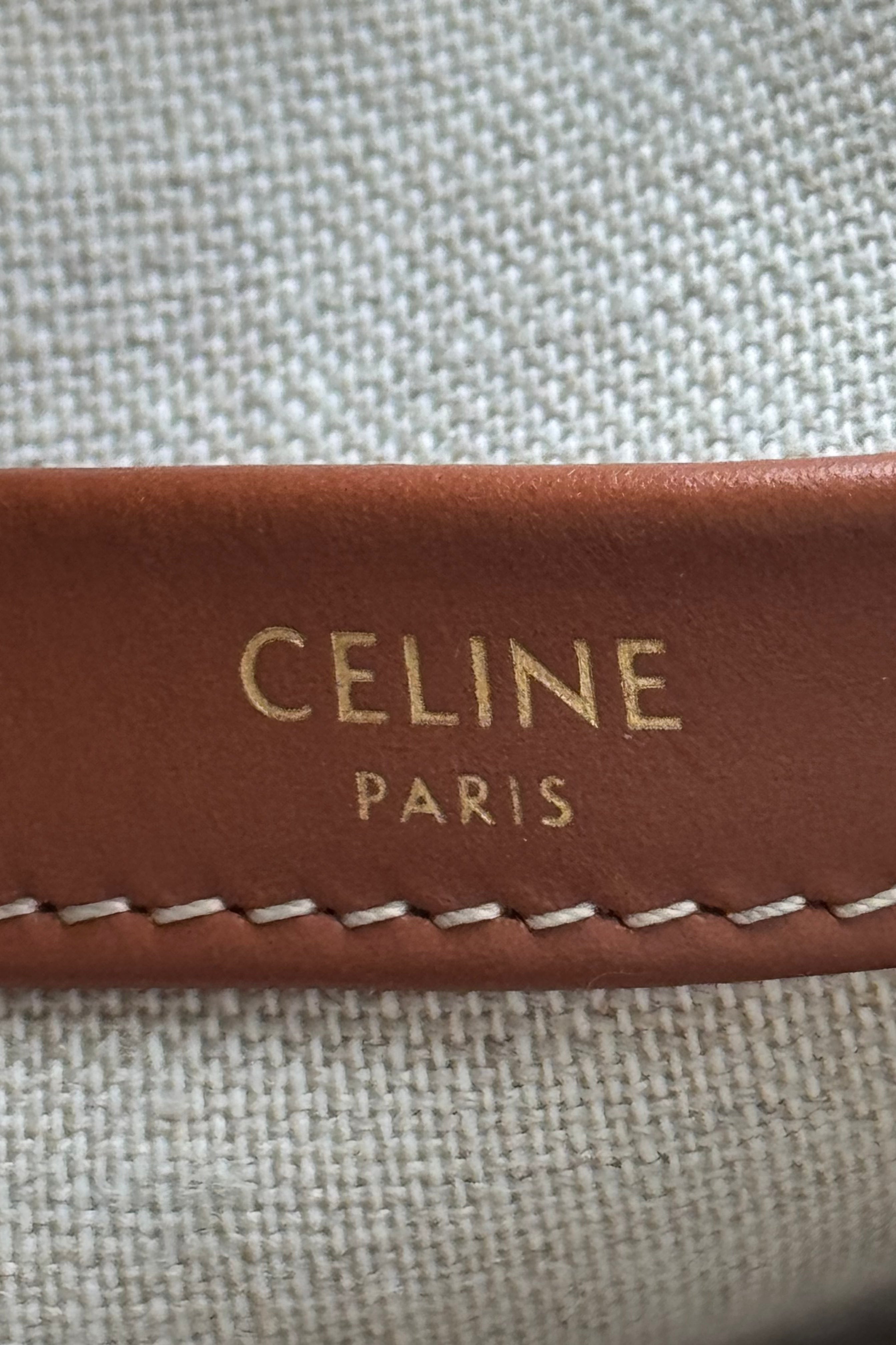 Close-up of the authentic Celine Small White Canvas Tote Bag leather logo patch embossed with CELINE PARIS branding.
