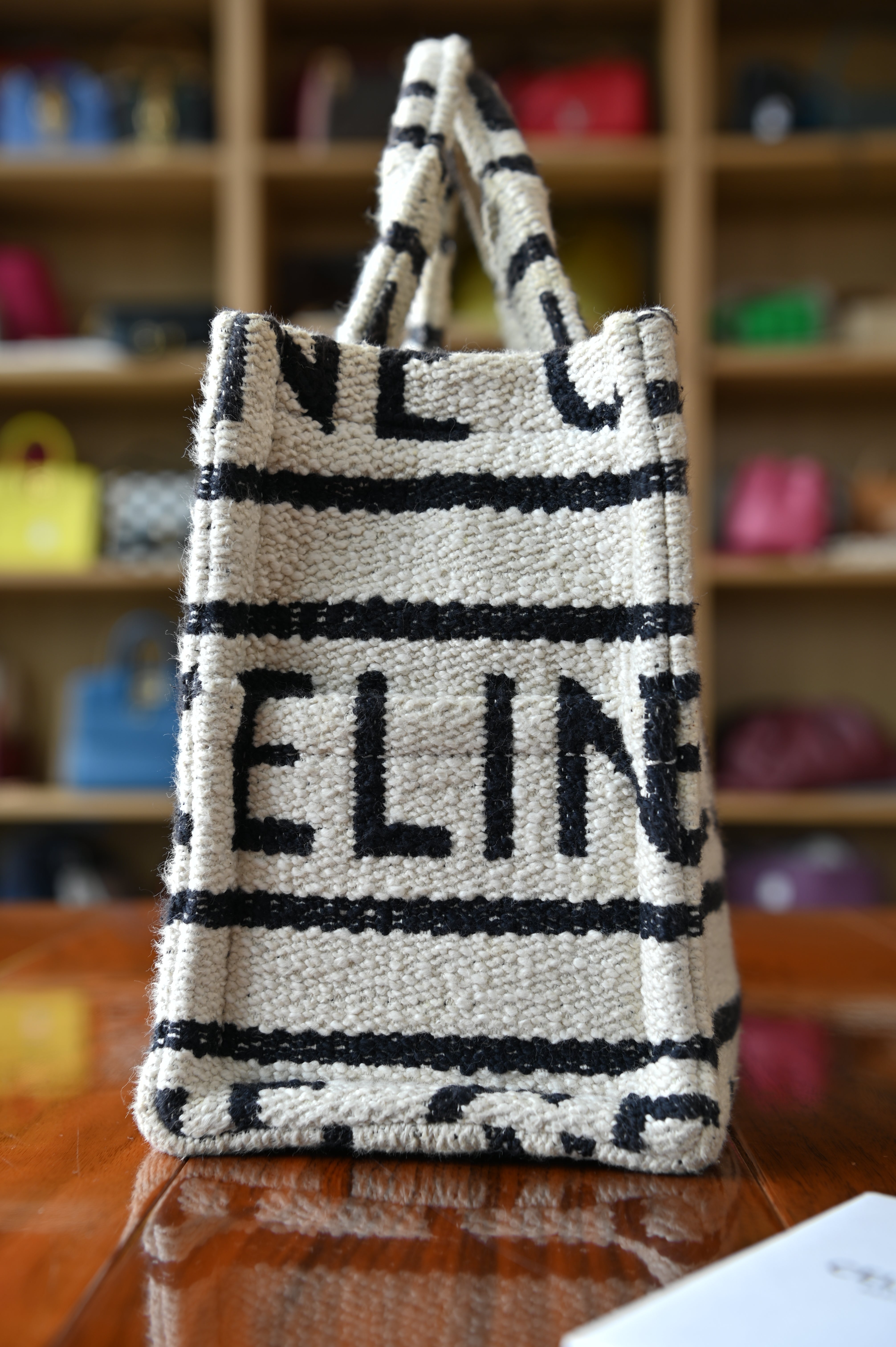 Authentic Celine Small White Canvas Tote Bag showing the left side profile with structured construction and detachable shoulder strap.