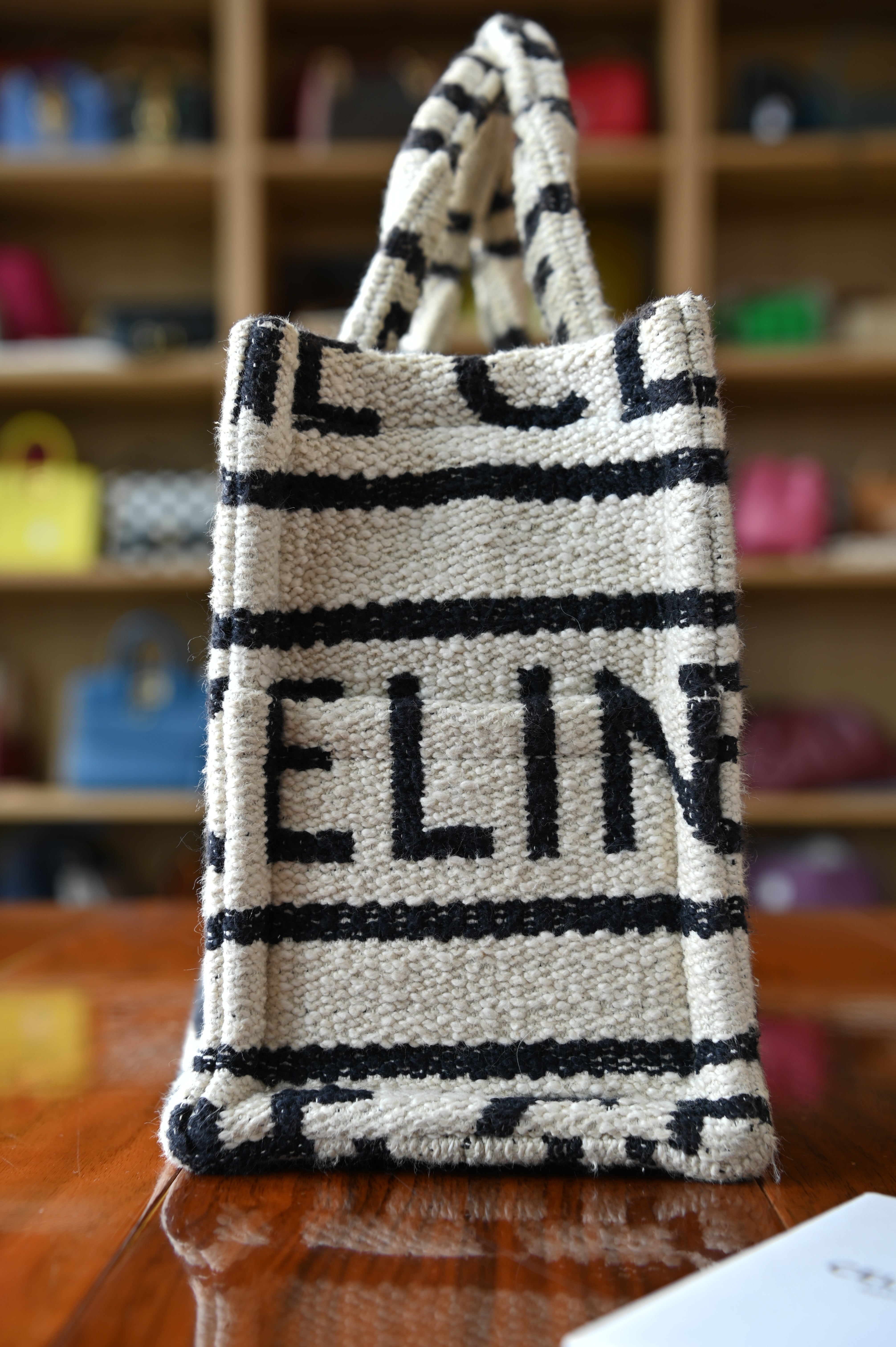Authentic Celine Small White Canvas Tote Bag showing the right side profile with leather trim and top handles.