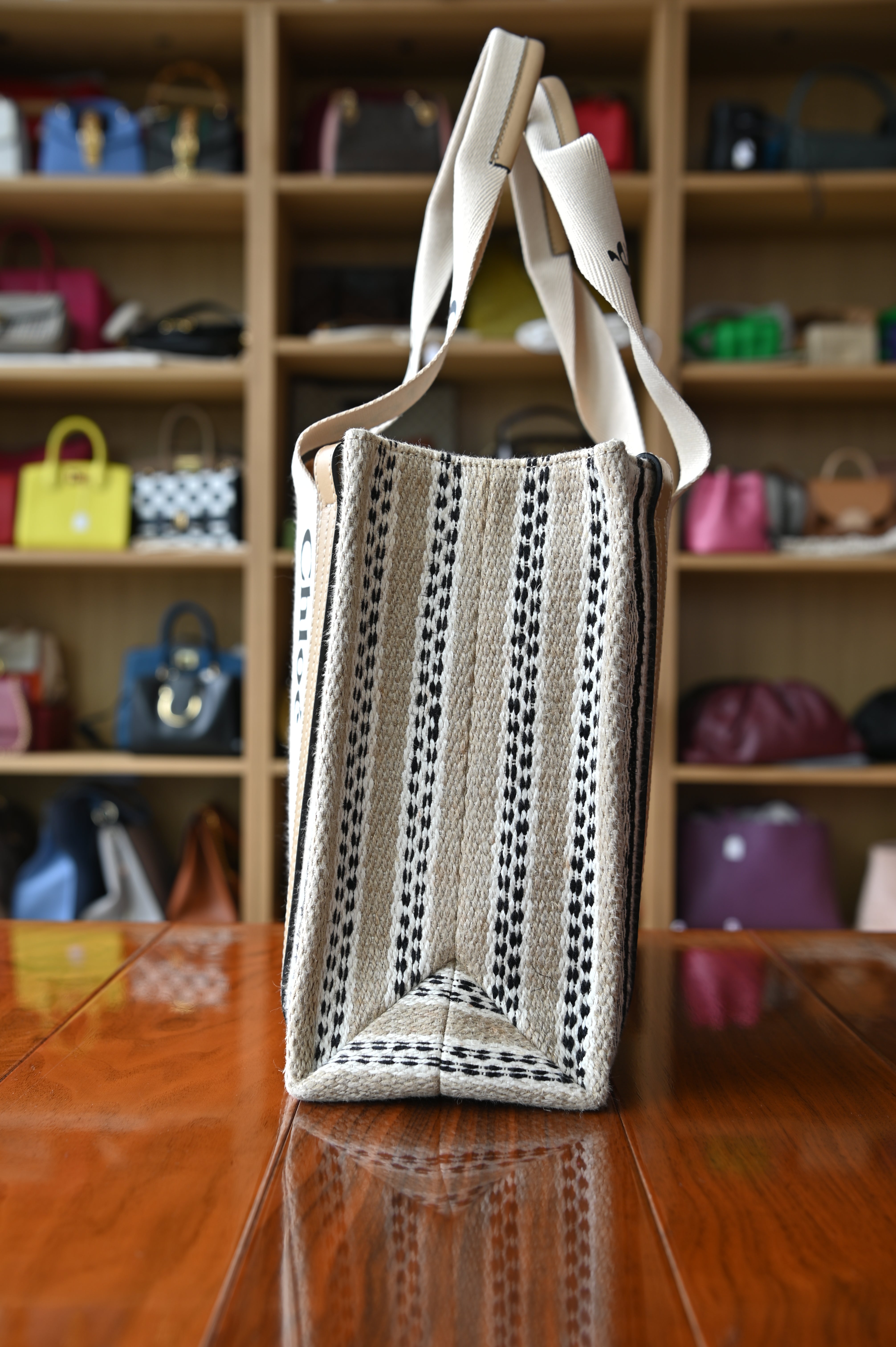 Authentic Chloé Woody Medium Striped Tote Bag showing the left side profile with striped canvas construction and logo handles.