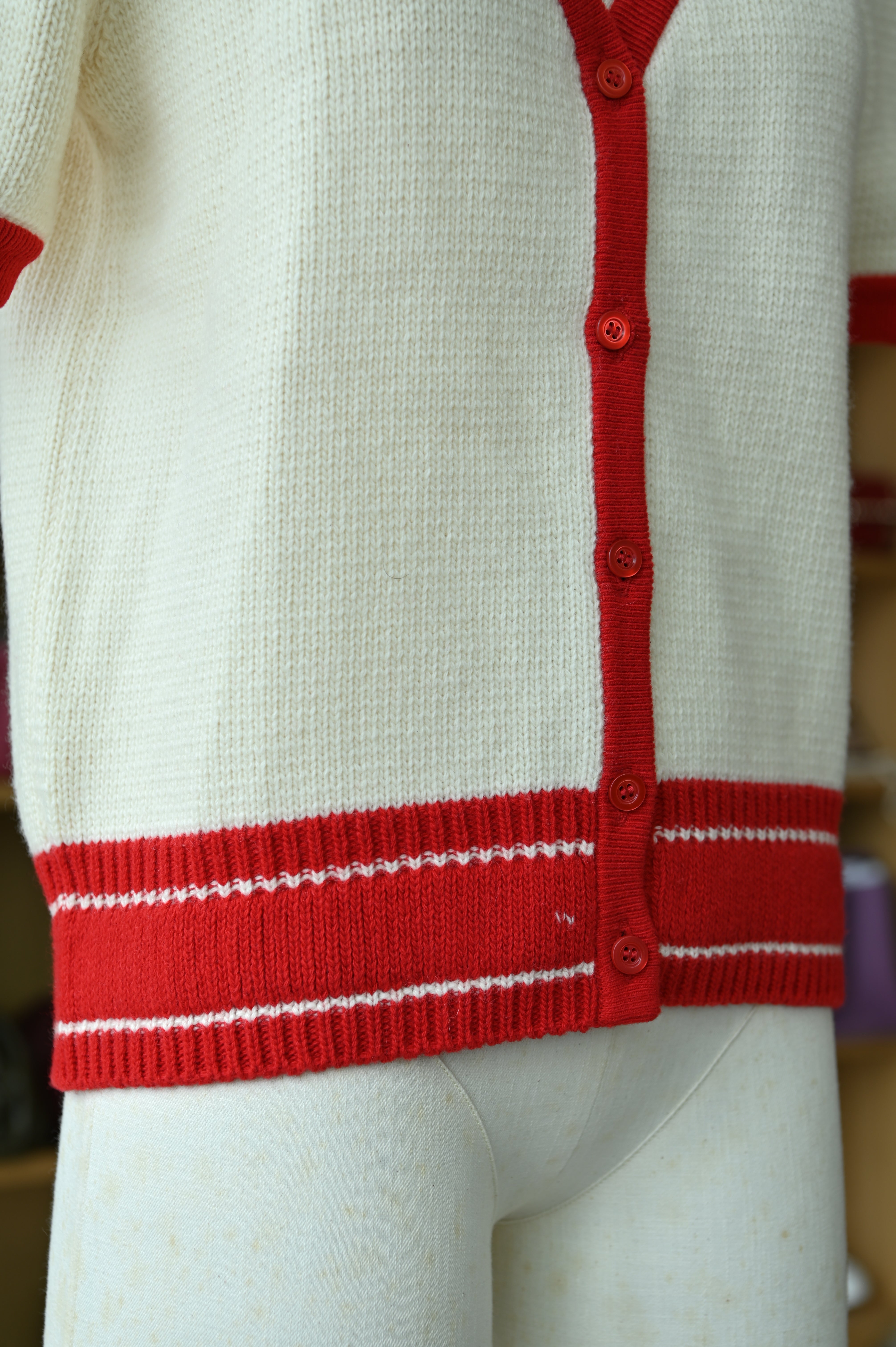 Close-up of the authentic Christian Dior White & Red Knit Cardigan showcasing the button closure and knit texture 