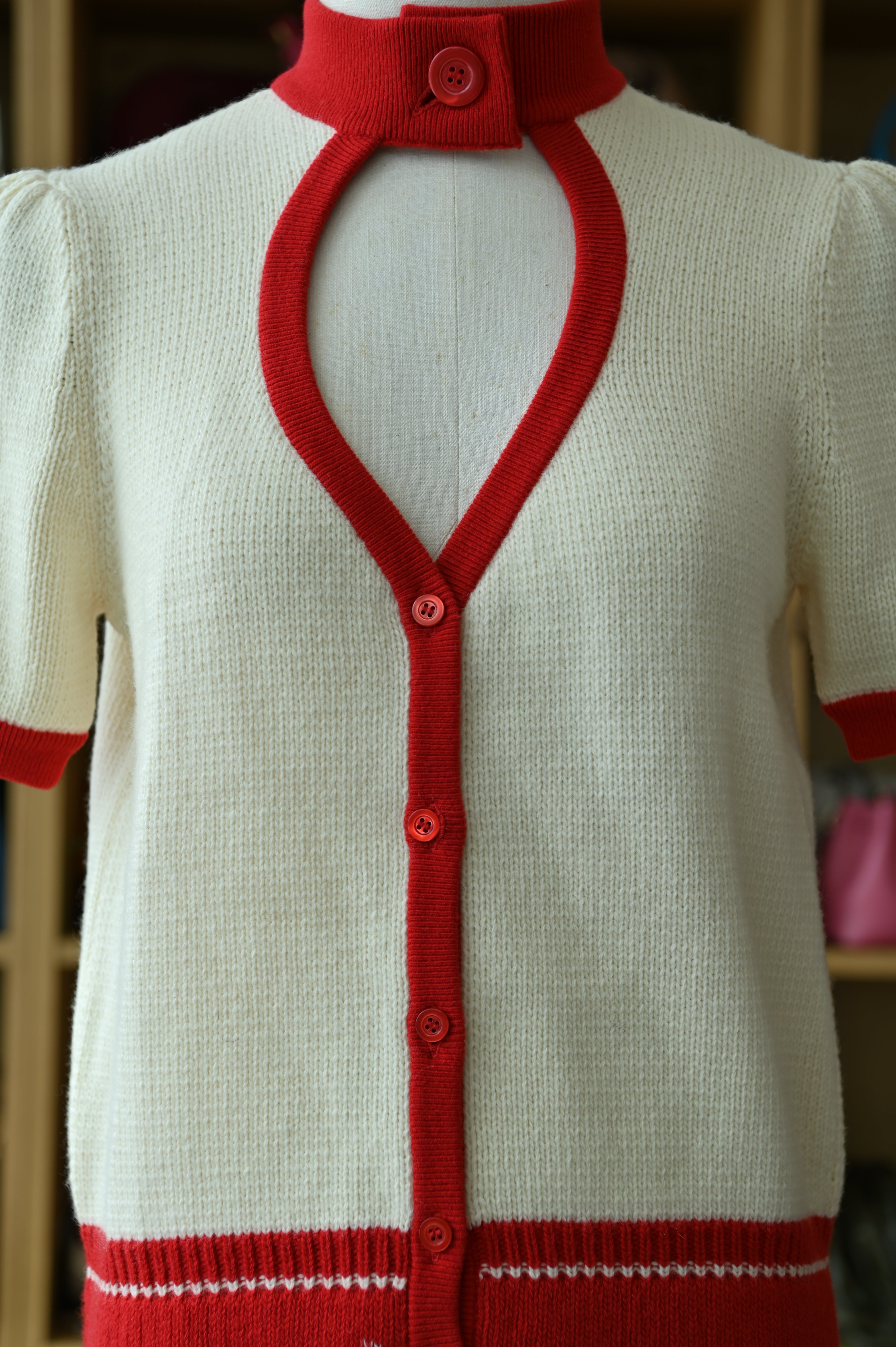Authentic Christian Dior White & Red Knit Cardigan showing the lapel neckline, front button closure and contrast trim