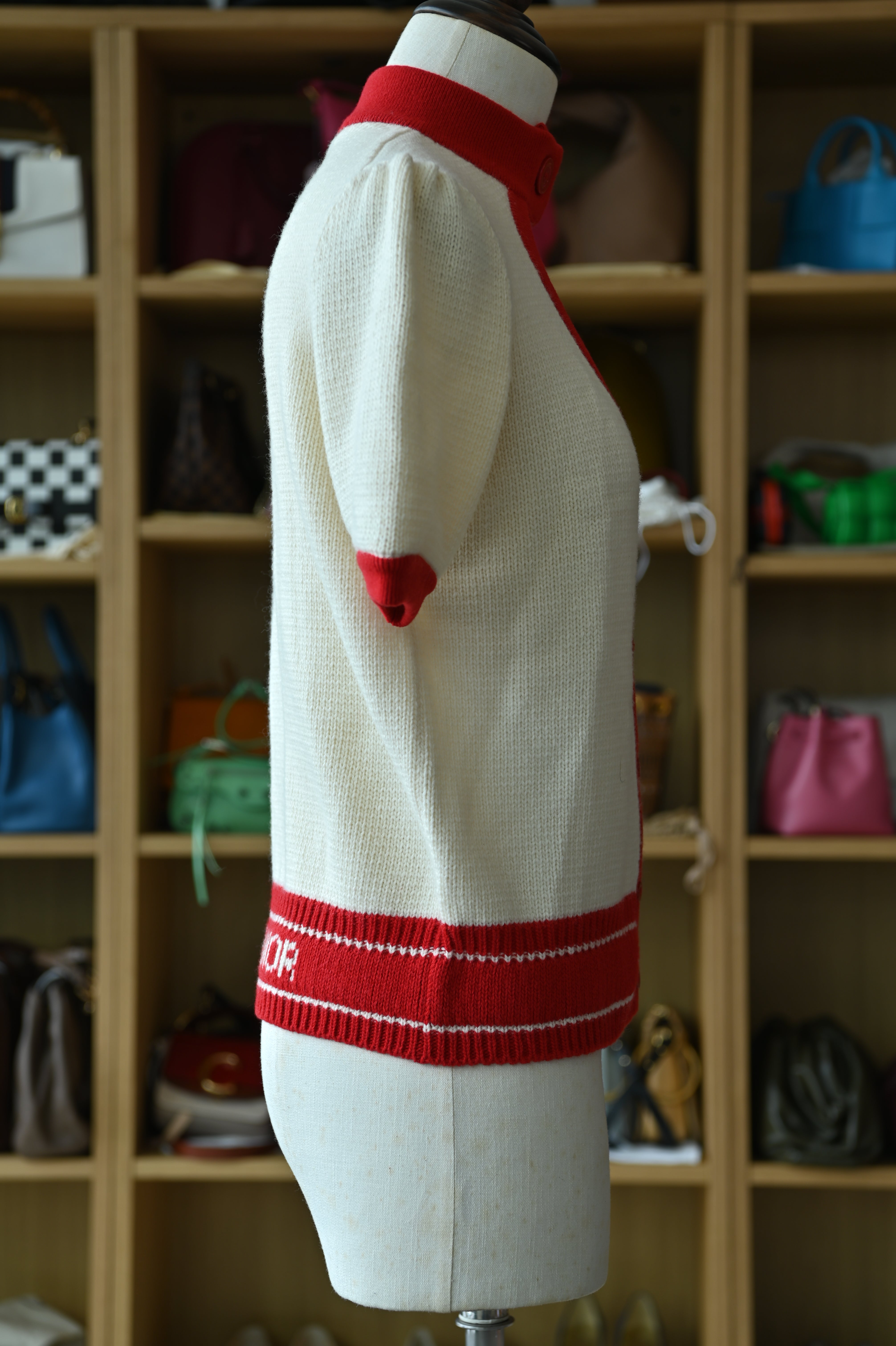 Authentic Christian Dior White & Red Knit Cardigan showing the right side profile with luxurious knit fabric and red trim.