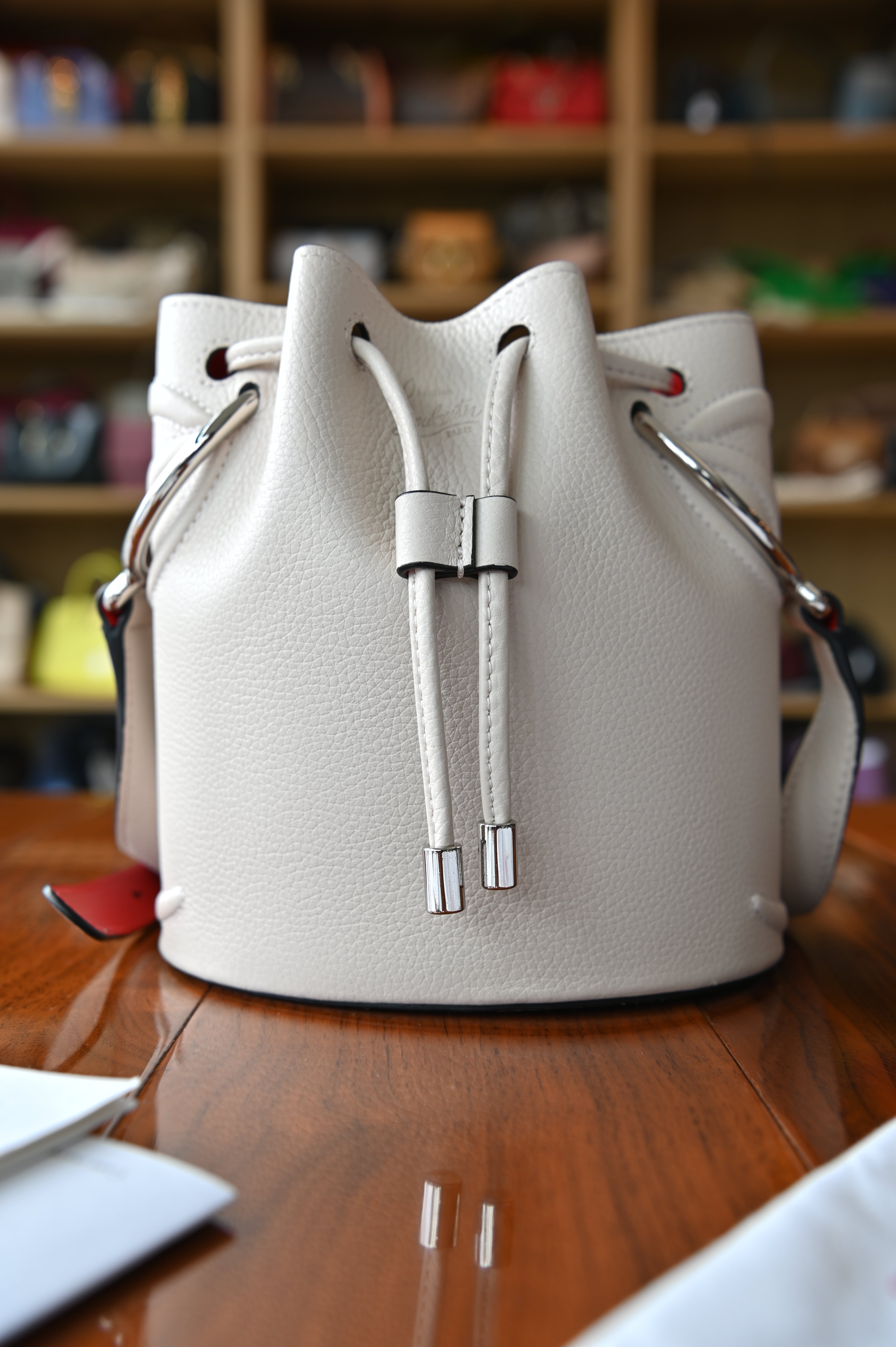 Authentic Christian Louboutin By My Side Light Pink Leather Bucket Bag with drawstring closure and silver-tone hardware, front view.