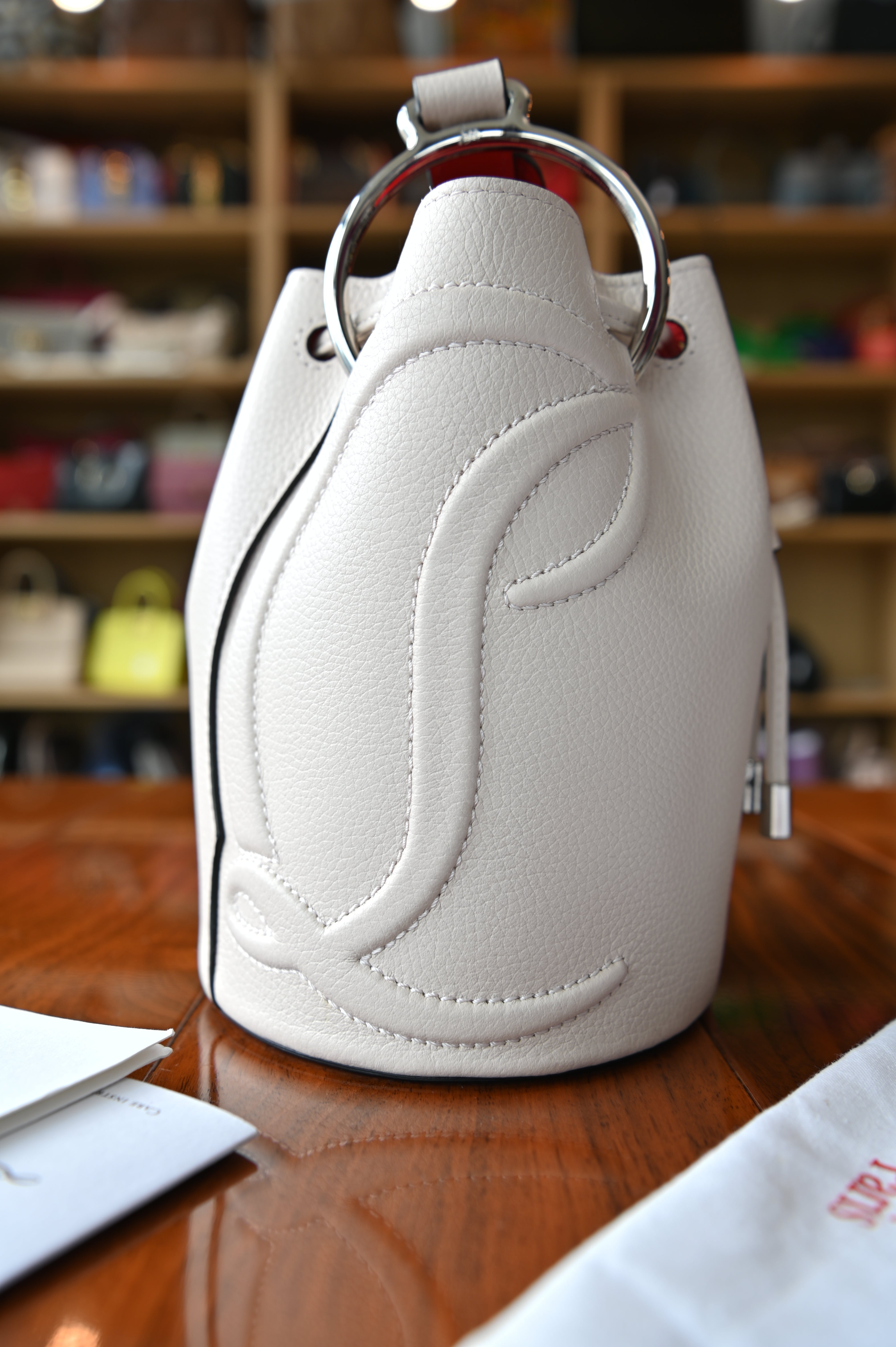 Authentic Christian Louboutin By My Side Light Pink Bucket Bag showing the opposite side with sculpted CL leather detailing.