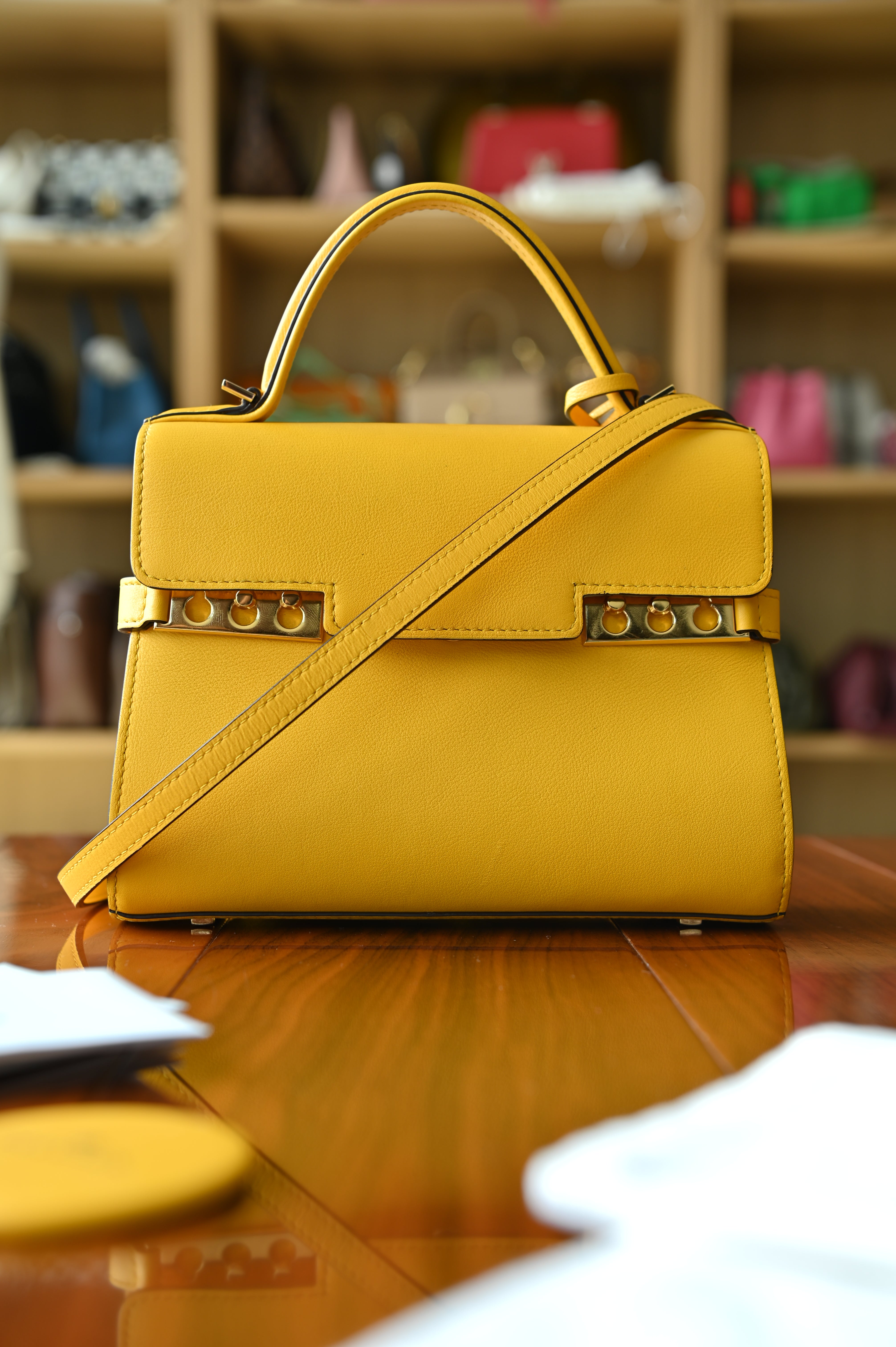 Authentic Delvaux Tempête Mini Souple Safra Yellow Leather Top Handle Bag showing the clean rear profile and structured leather construction.
