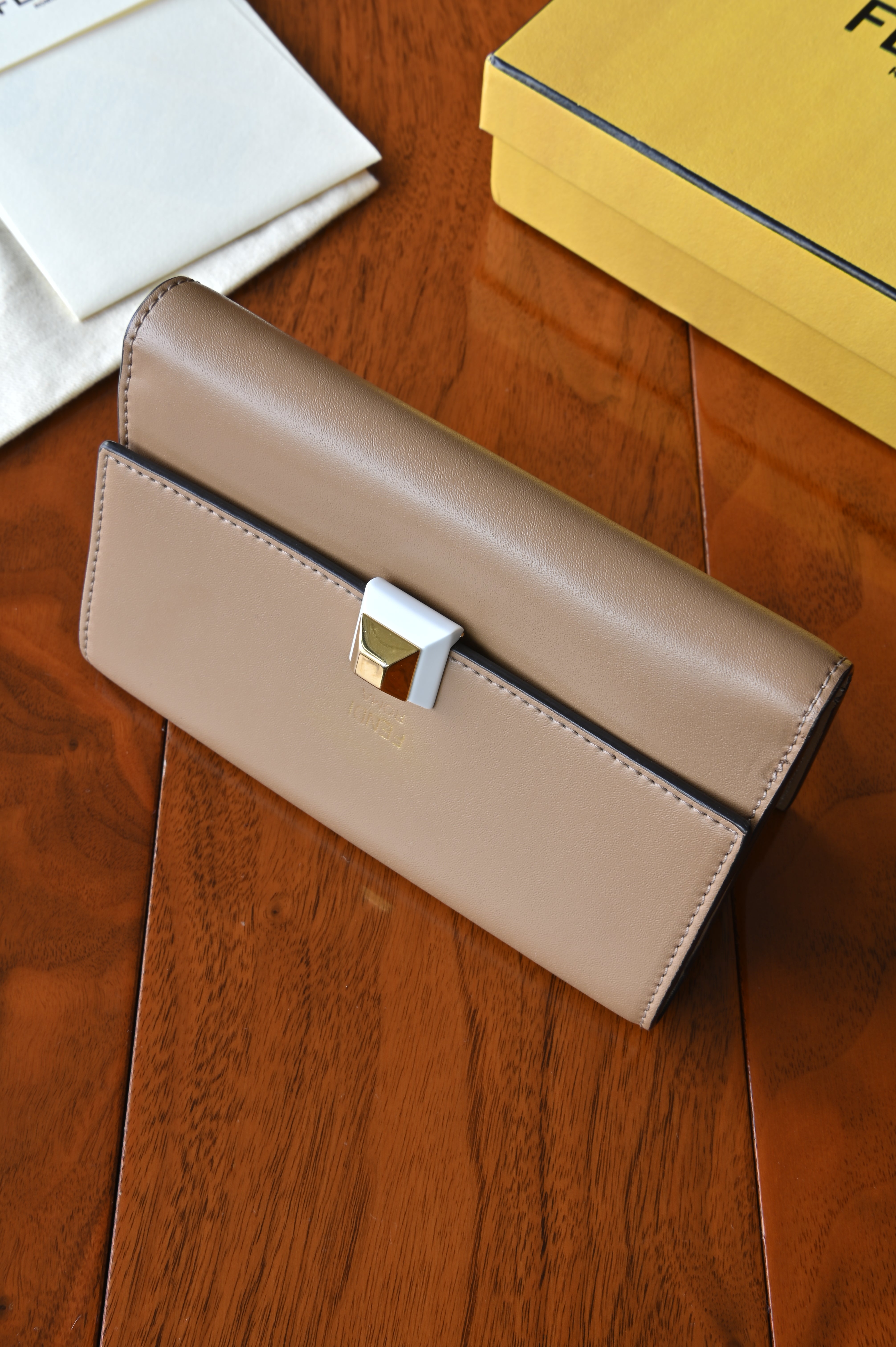 Front angled view of the authentic Fendi beige leather continental wallet with signature pyramid push-lock closure.
