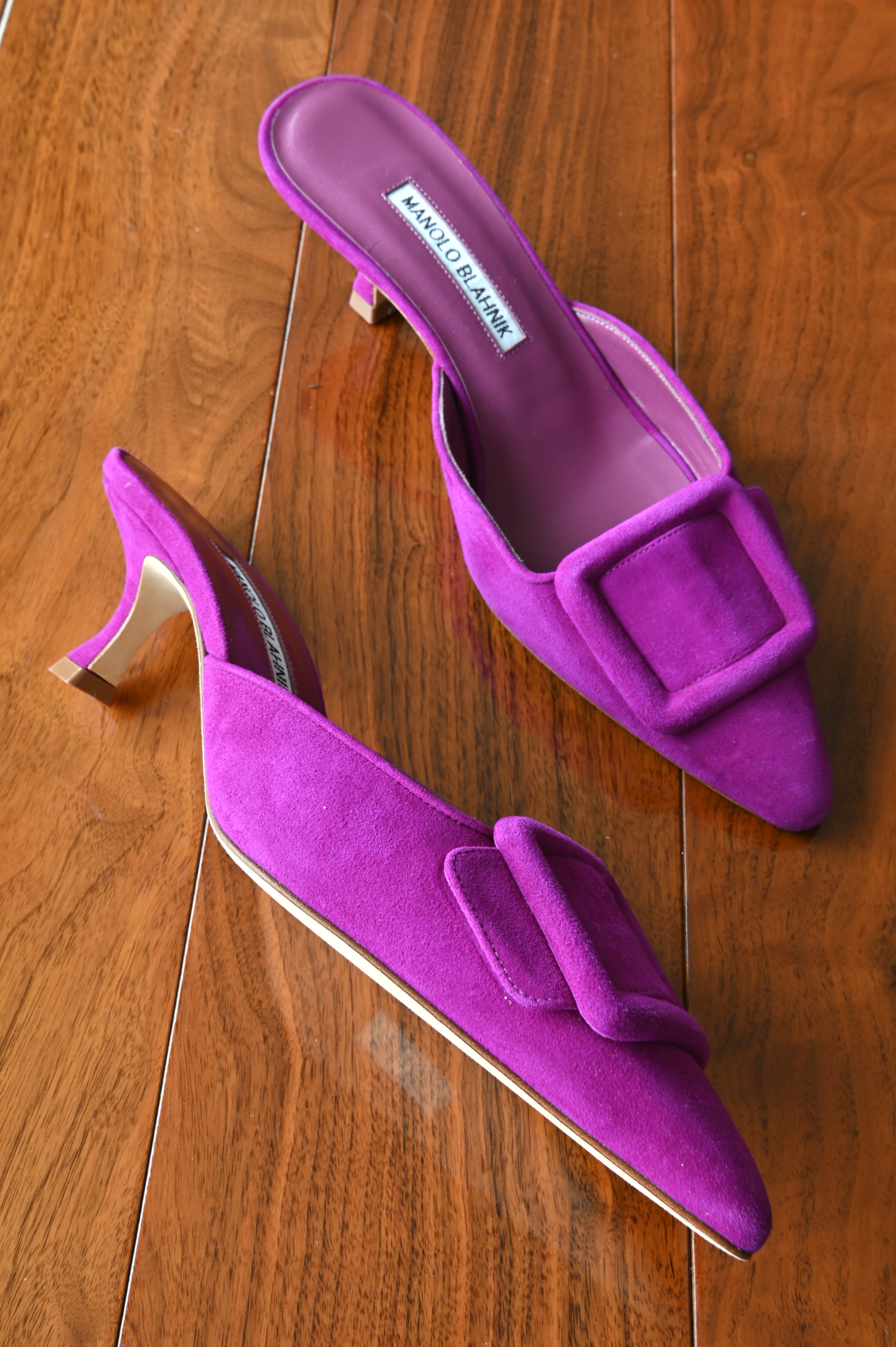Side profile of authentic Manolo Blahnik purple suede buckle mules highlighting the approximately 2-inch kitten heel and pointed toe design