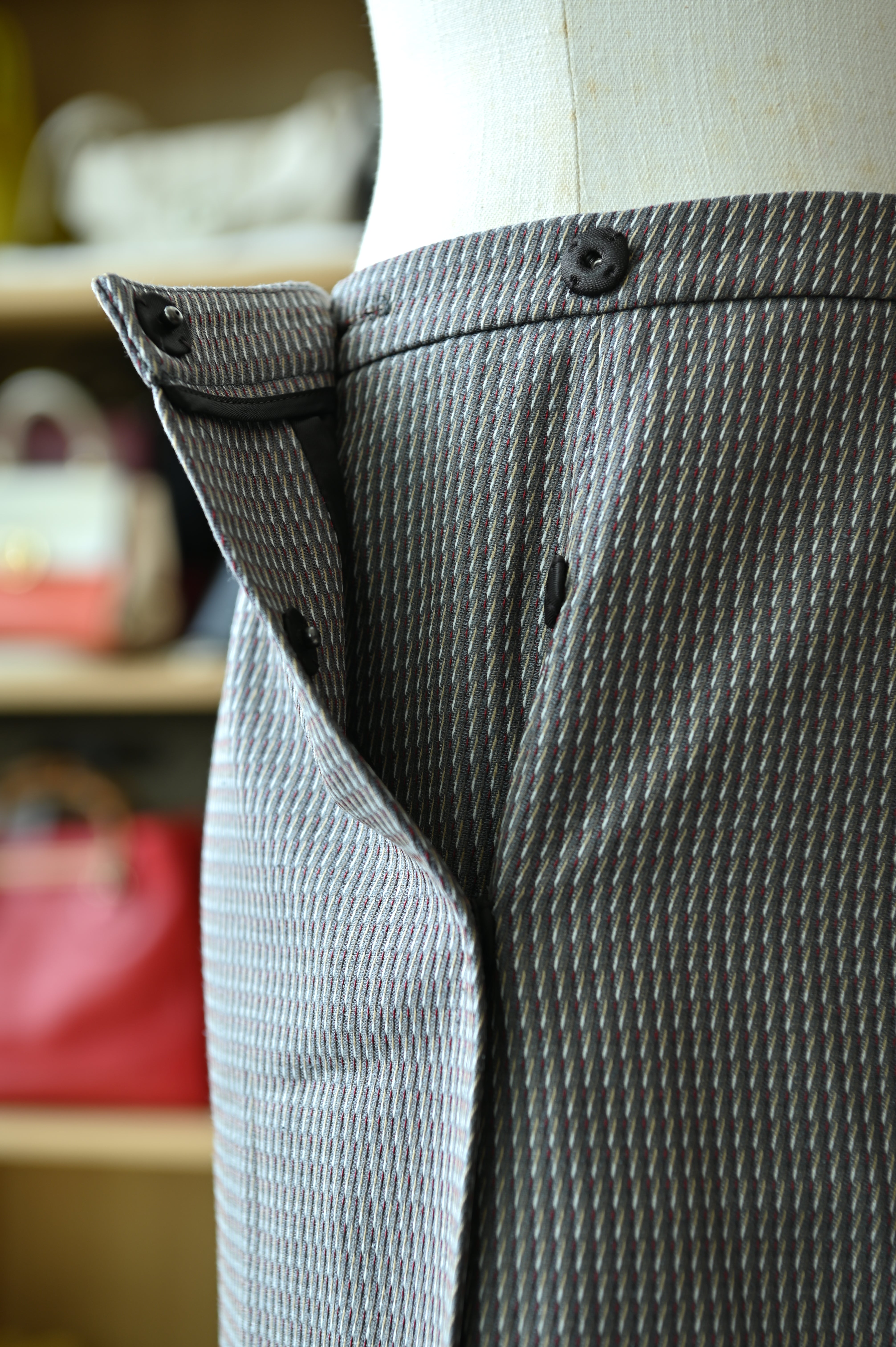 Close-up of the authentic Miu Miu Grey Checked Pencil Skirt showing the waistband, button fastening and checked fabric.