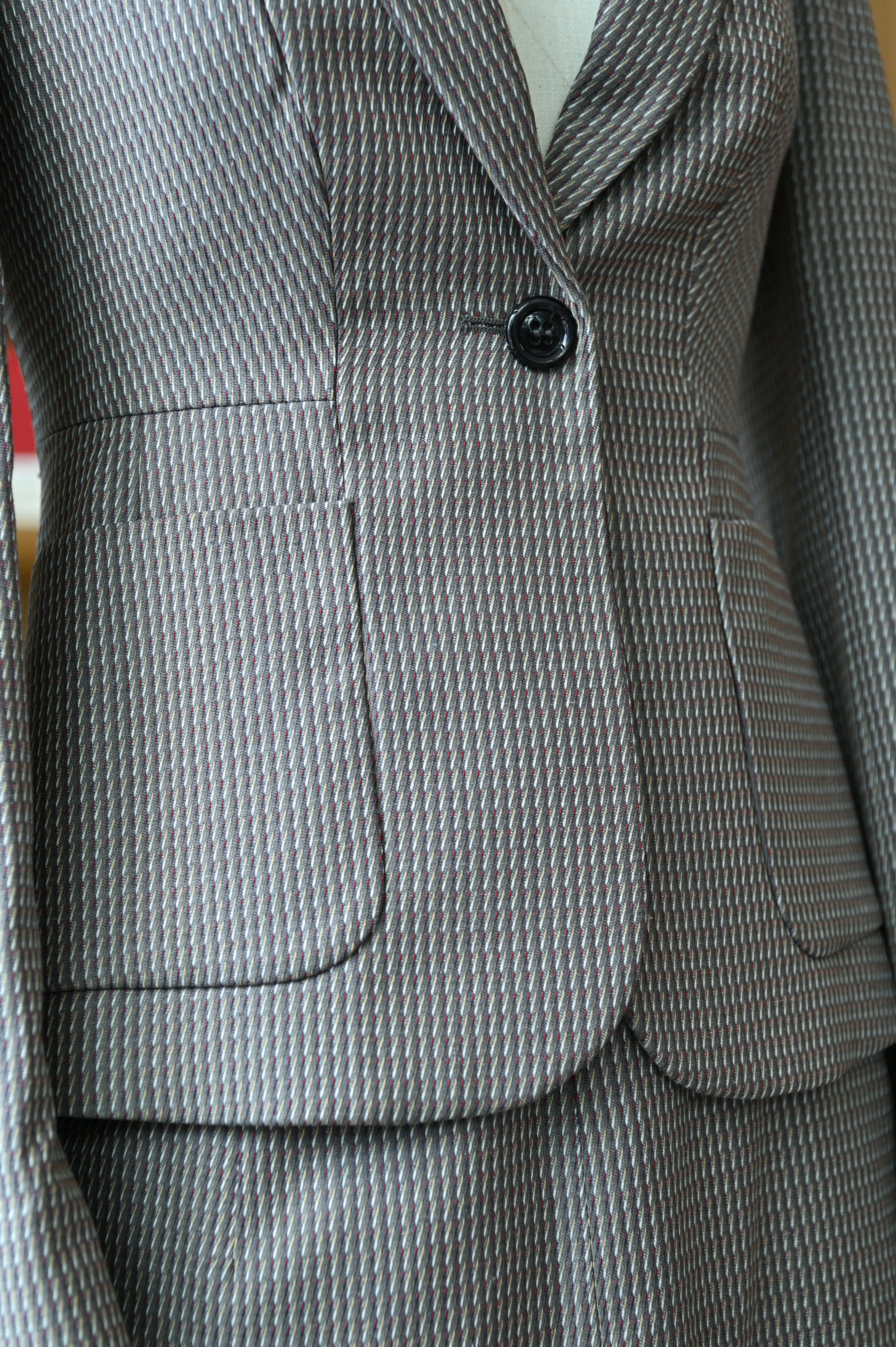Close-up of the authentic Miu Miu Grey Checked Two-Piece Skirt Suit highlighting the tailored lapels, single-button closure and front pockets.