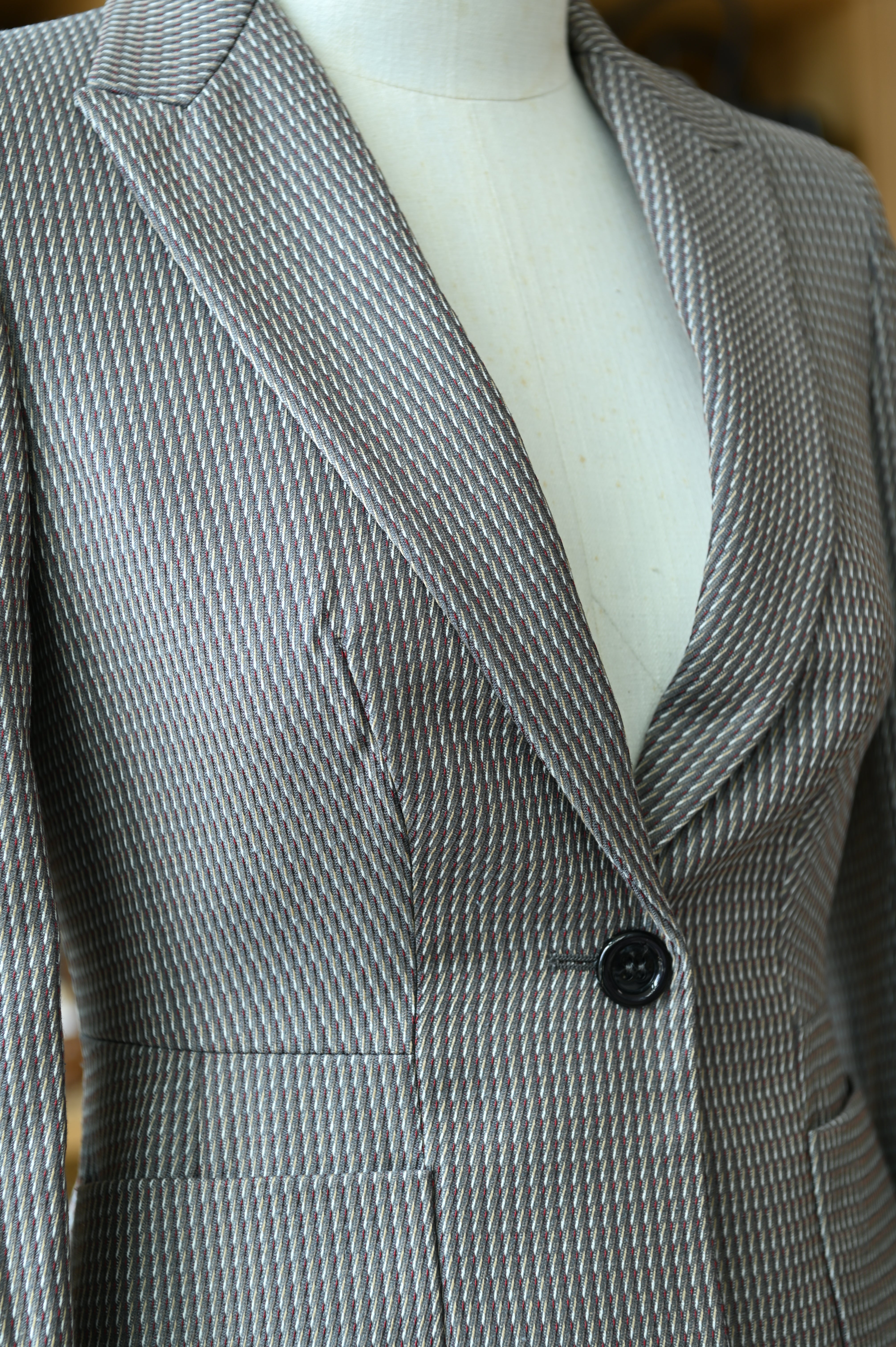 Close-up of the authentic Miu Miu Grey Checked Two-Piece Skirt Suit showcasing the lapel design, checked fabric and precise tailoring.