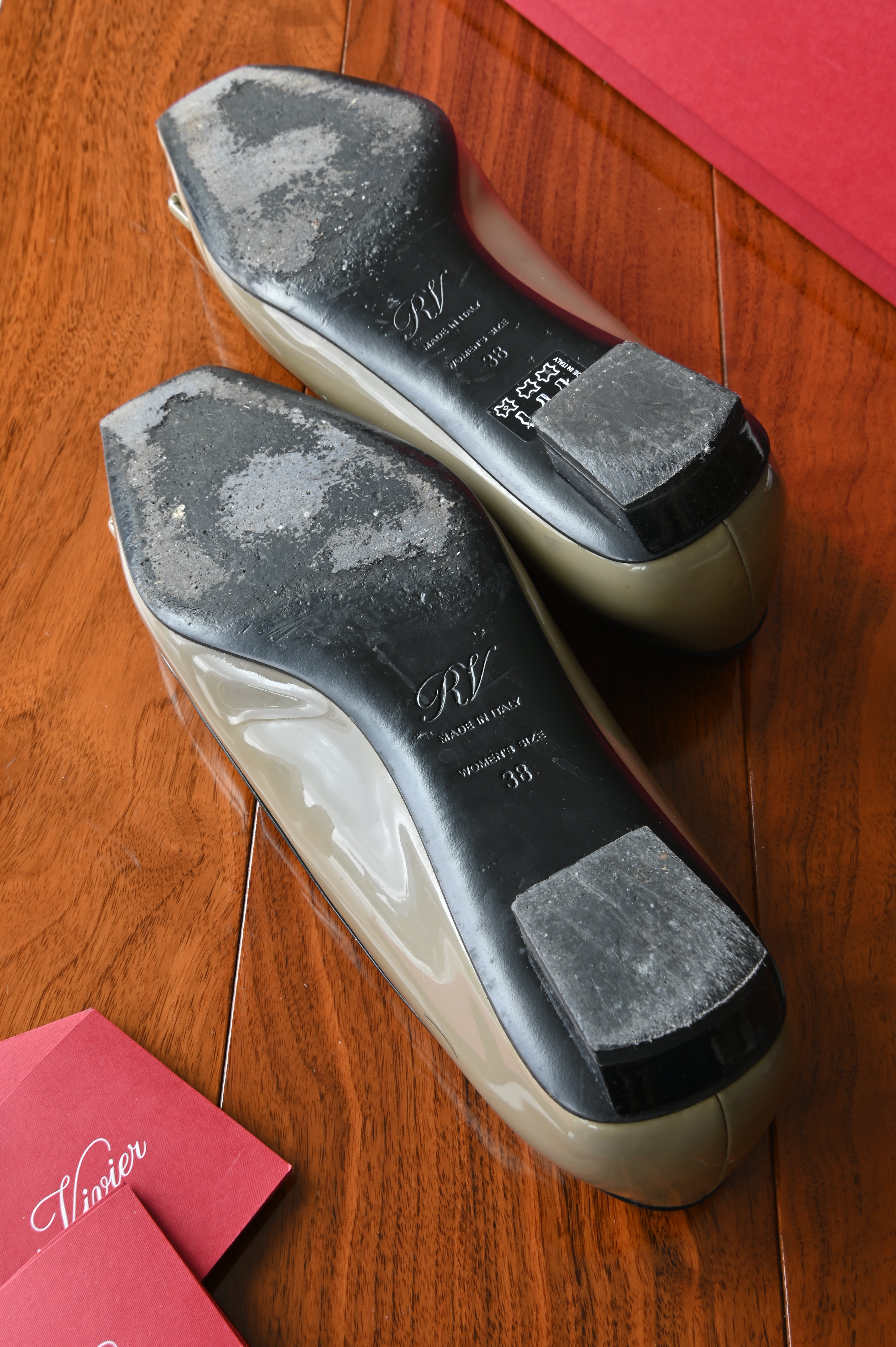 Bottom view of authentic Roger Vivier Belle Vivier patent leather pumps showing normal wear to the leather outsoles from previous use.