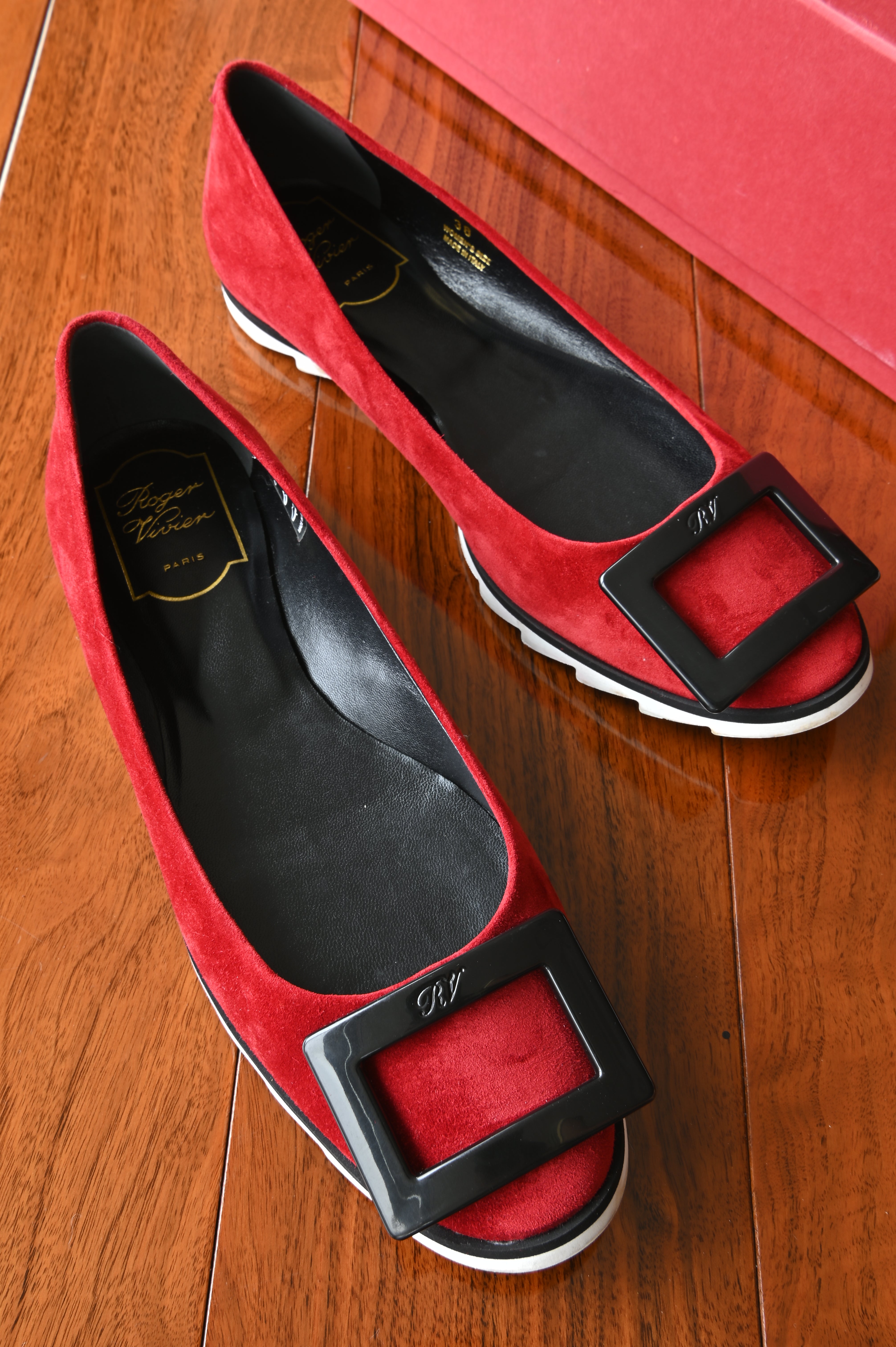 Authentic Roger Vivier Gommettine red suede ballet flats, front angled view showcasing the signature oversized black buckle and elegant silhouette.