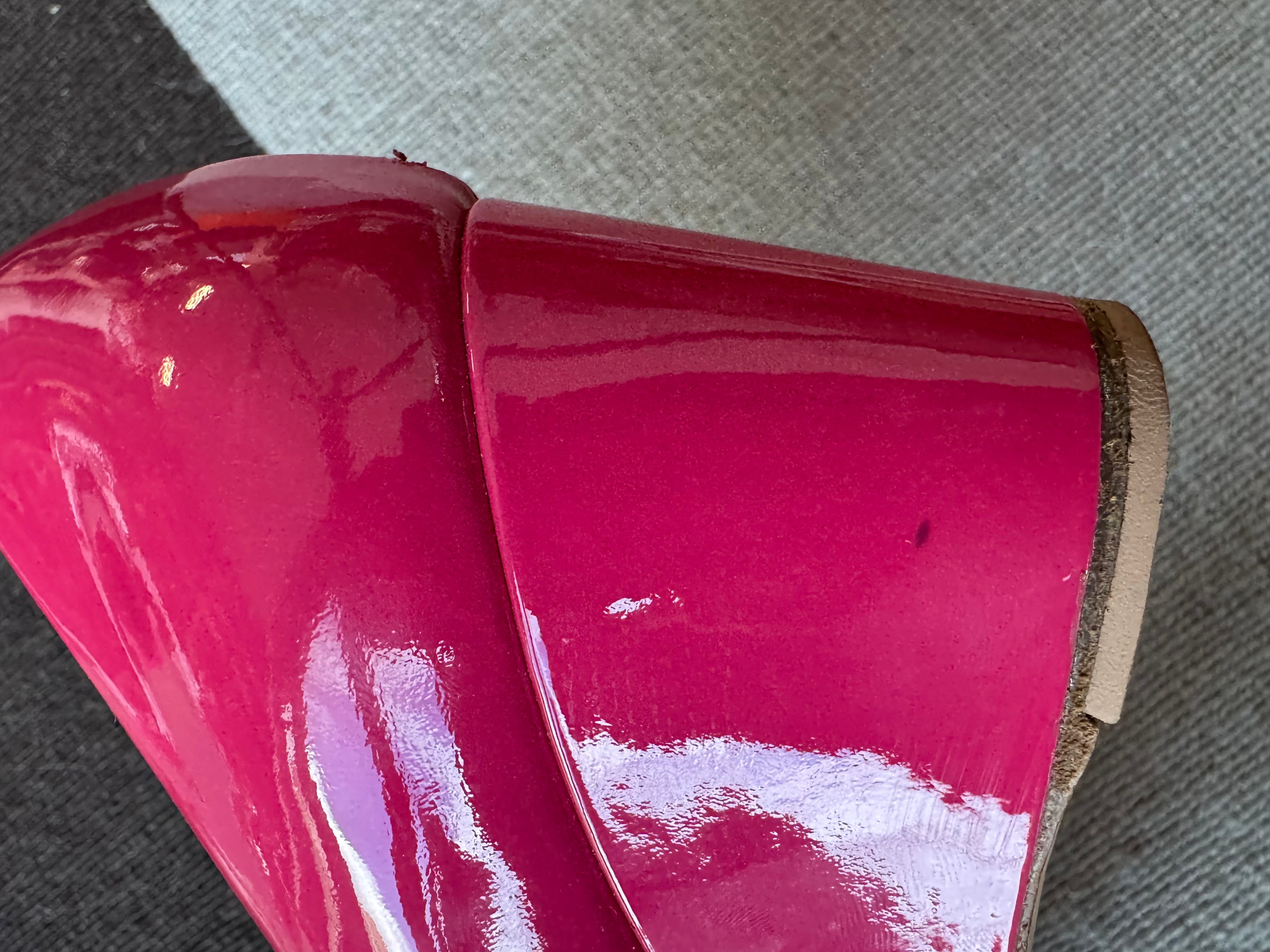Close-up showing the small dark spot on the left wedge heel of the authentic Salvatore Ferragamo pink patent leather Vara Bow Wedge Pumps