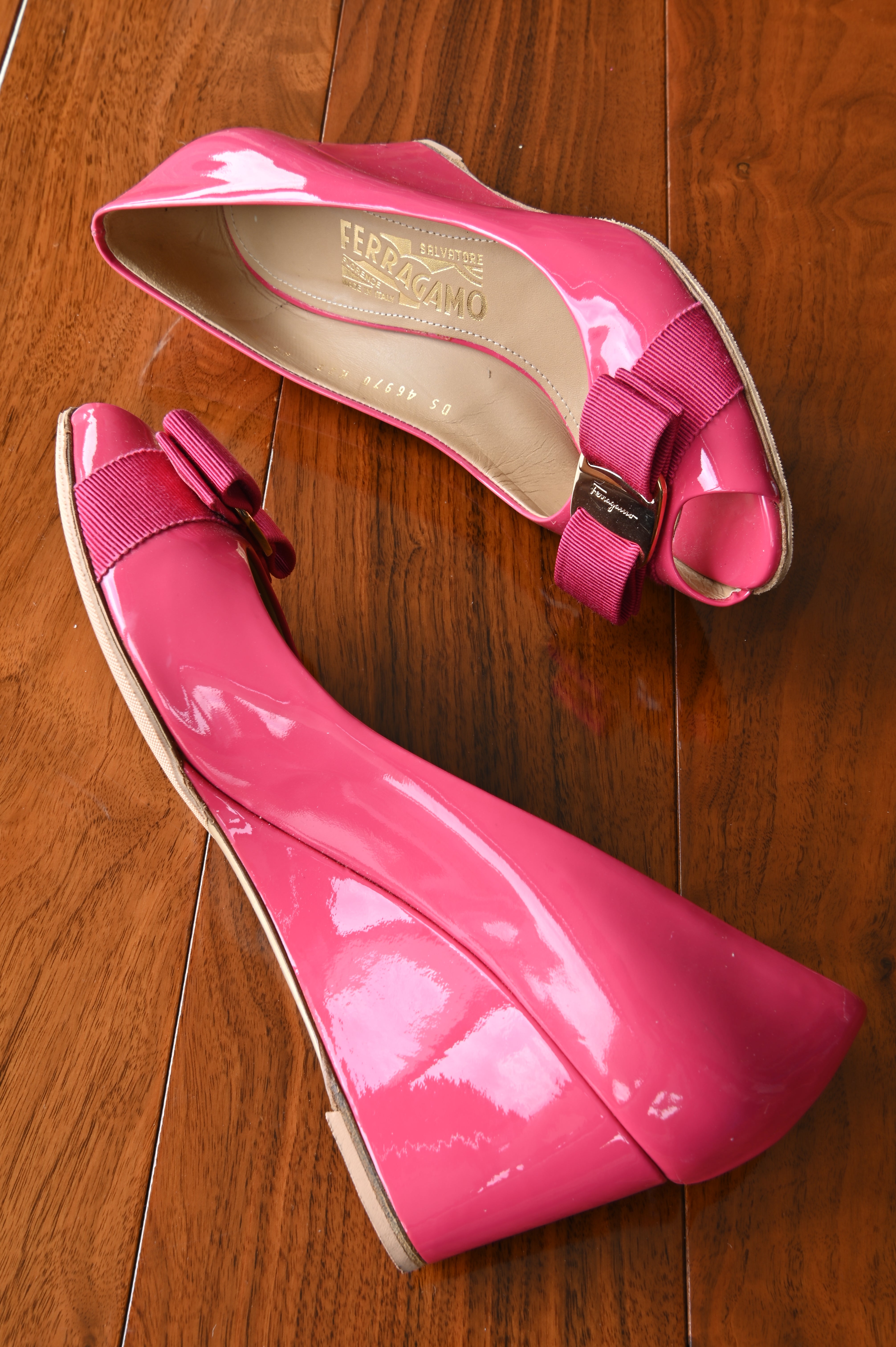 Angled side view of authentic Salvatore Ferragamo pink patent leather Vara Bow Wedge Pumps showcasing the glossy patent finish, elegant wedge heel, and signature Vara bow.