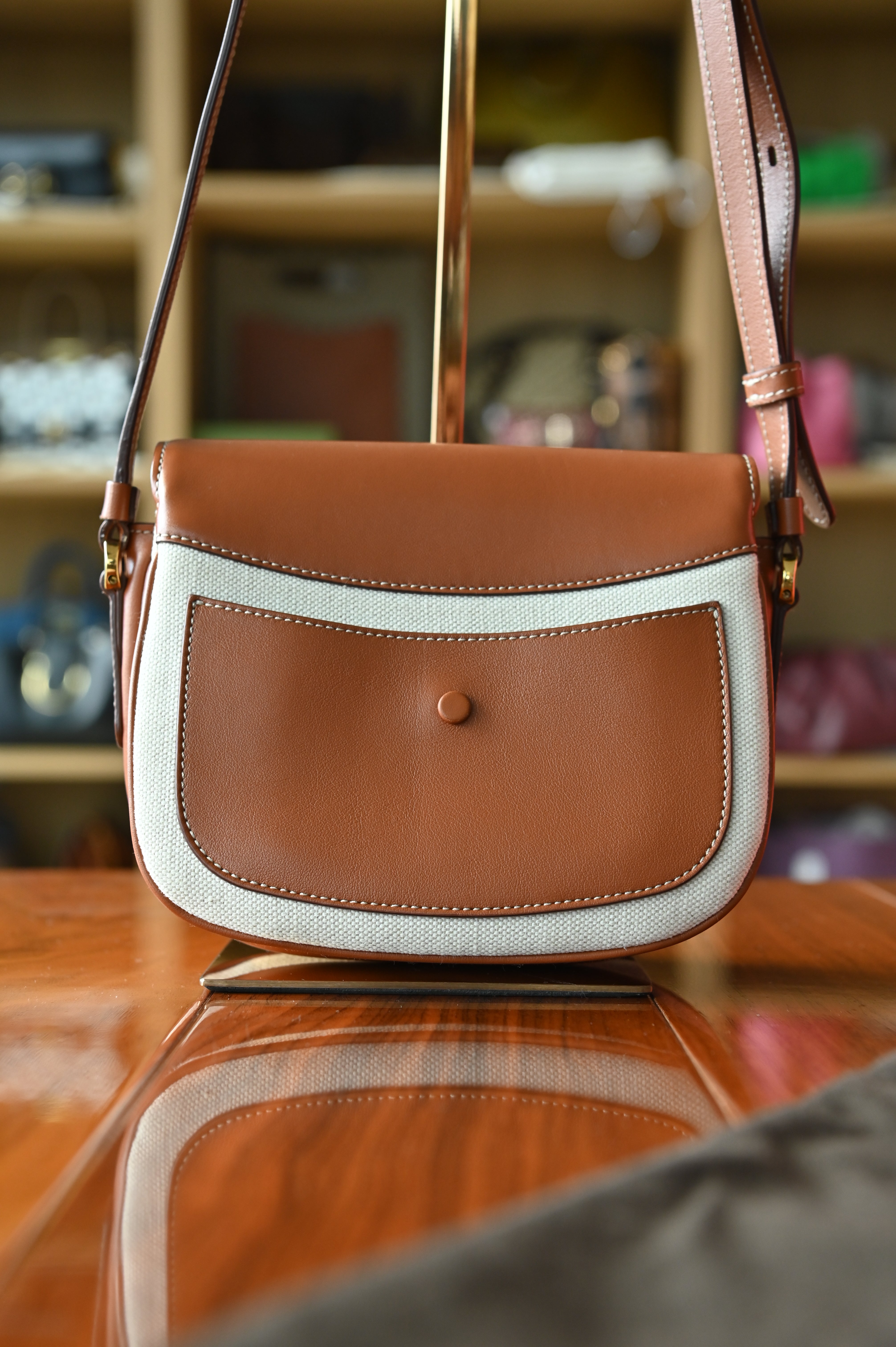 Authentic Tod’s Brown & Beige Canvas Logo Crossbody Bag showing the rear canvas panel with smooth brown leather trim and adjustable strap.