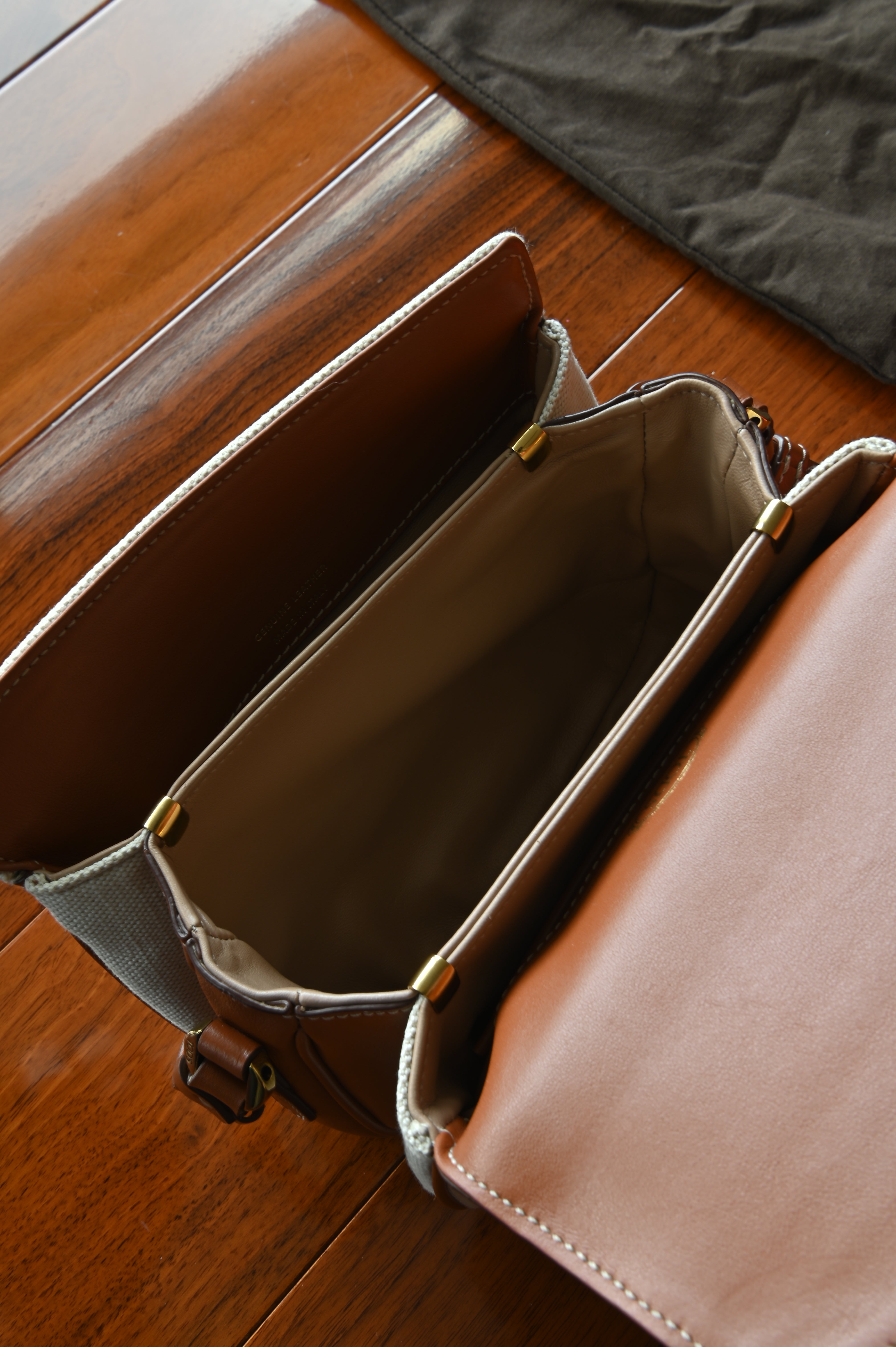 Authentic Tod’s Brown & Beige Canvas Logo Crossbody Bag showing the clean interior compartment with leather trim and spacious storage.
