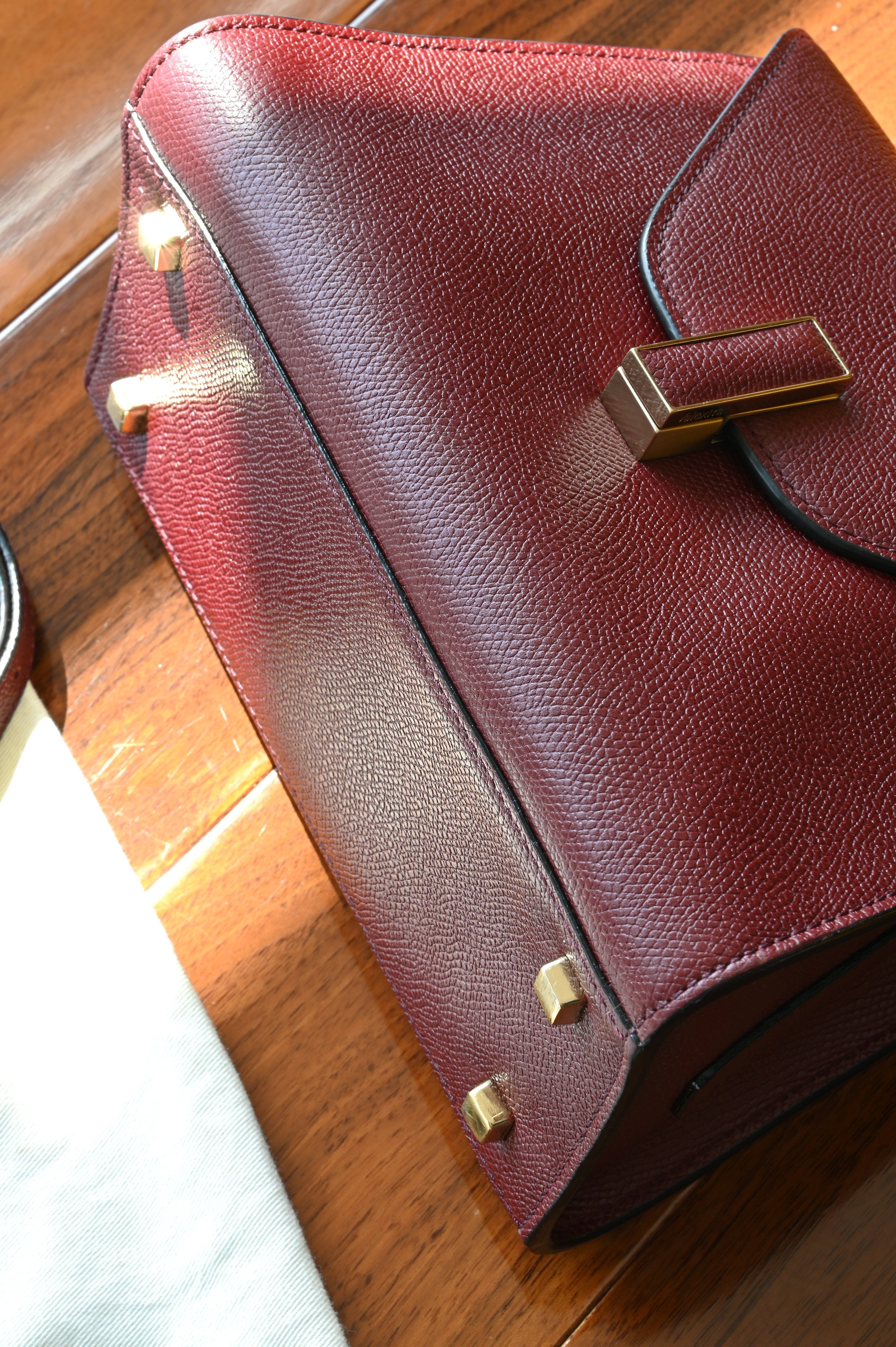 Detailed close-up of the Valextra Iside bag’s protective metal feet and pristine grained leather base.