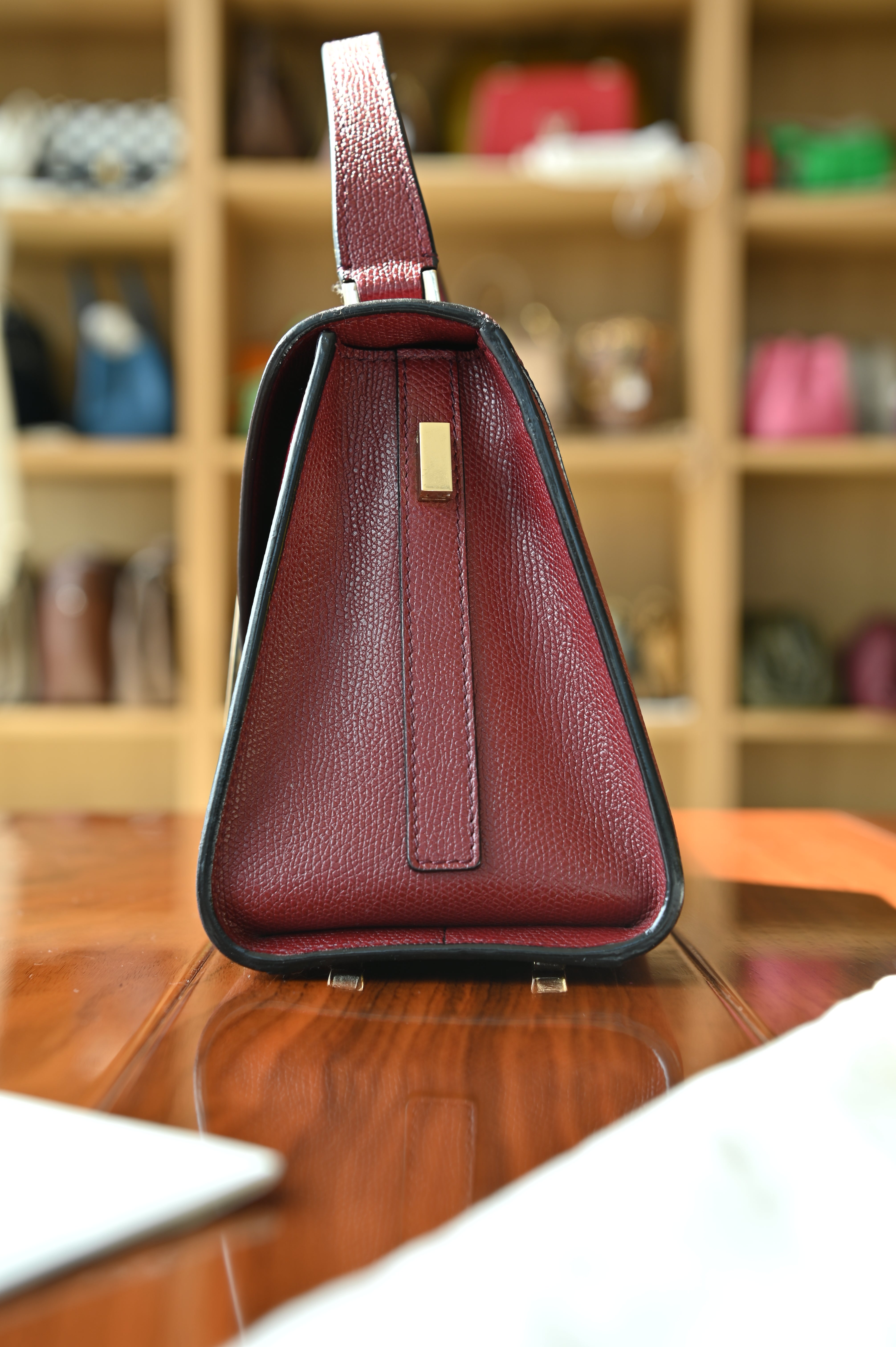 Left side profile of the authentic Valextra Iside handbag highlighting its structured gusset and premium Italian craftsmanship.