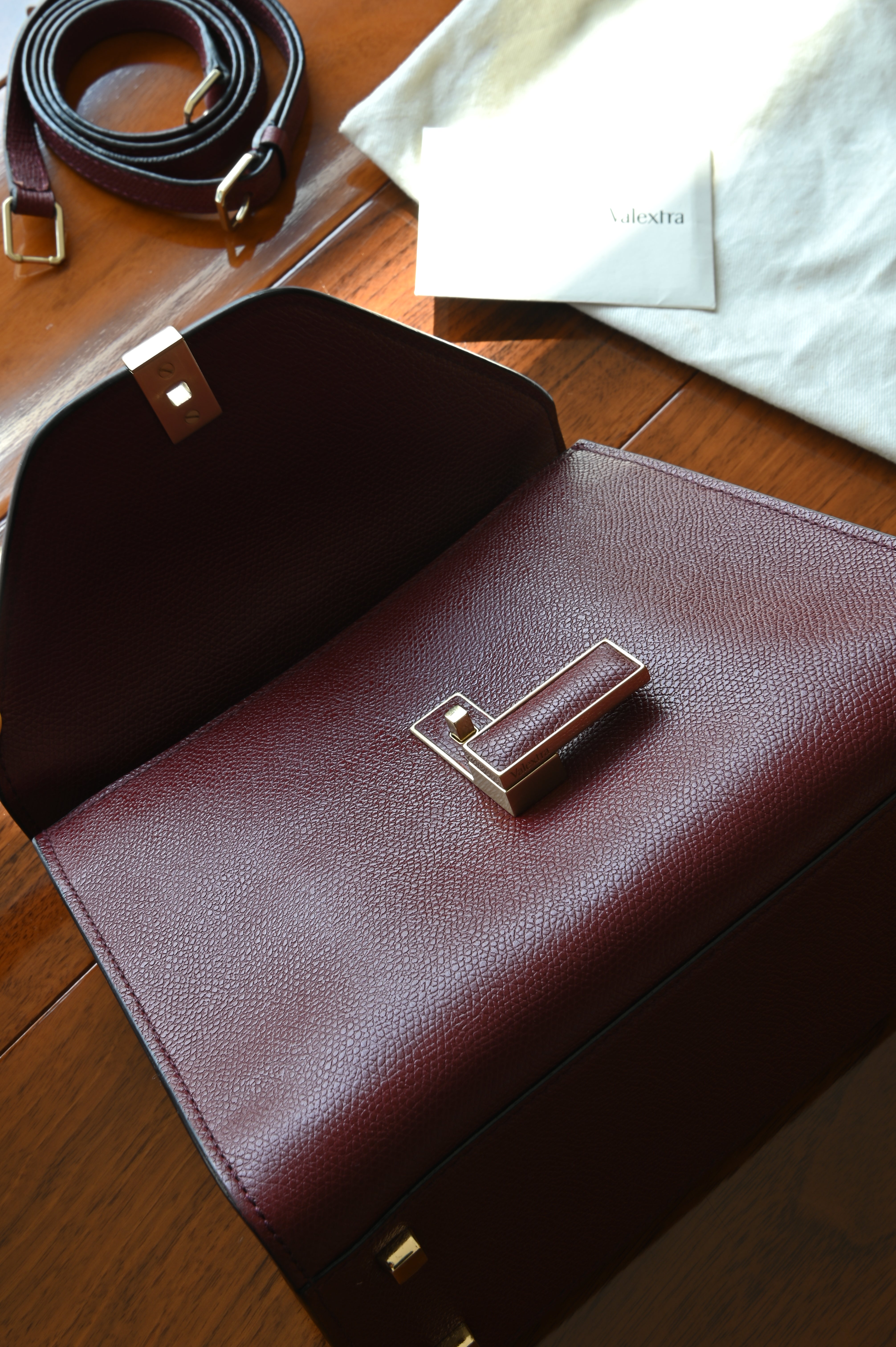 Open view of the authentic Valextra Iside handbag showcasing the clean leather-lined interior and signature V-shaped lock mechanism.